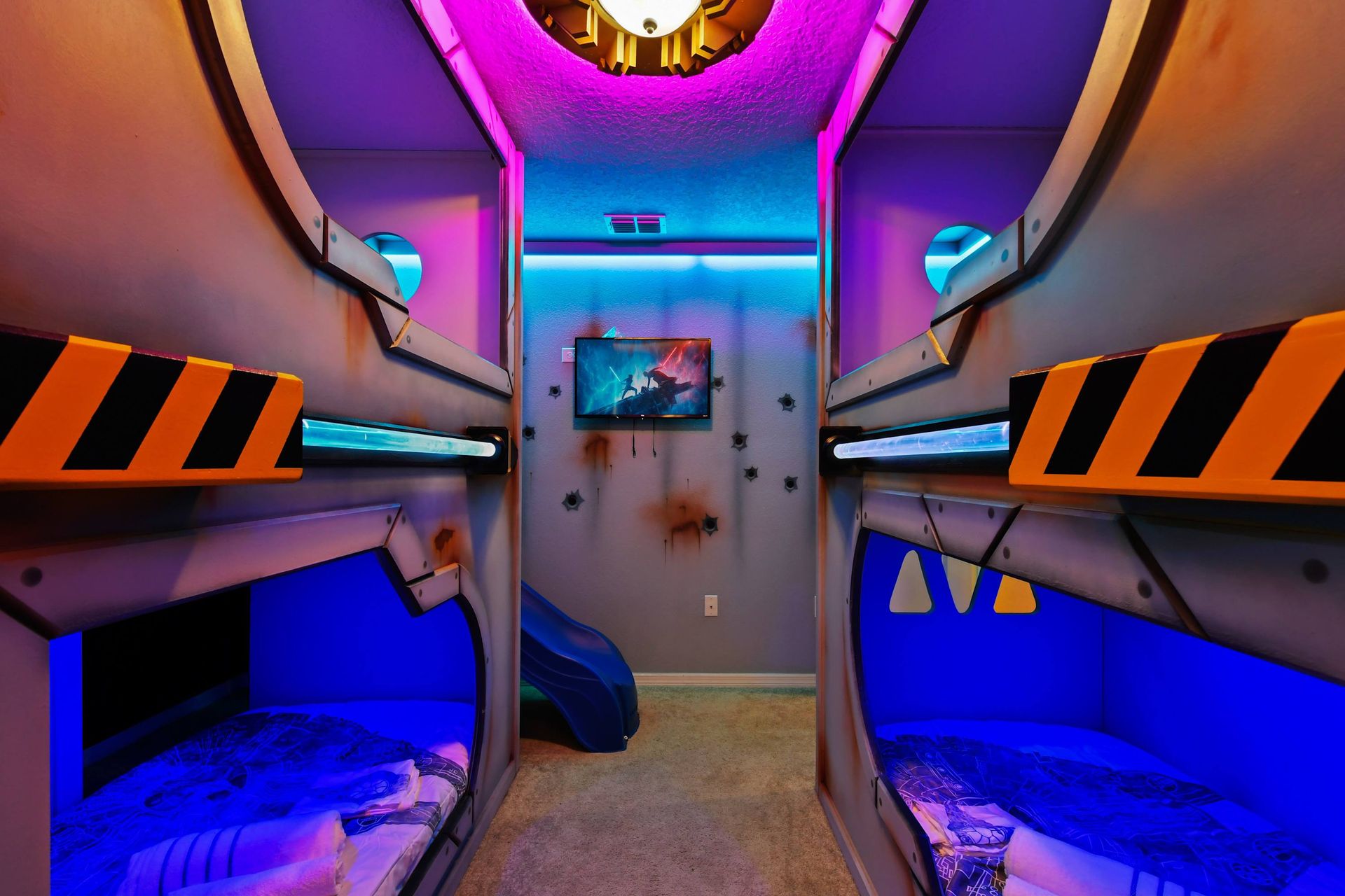 Epic galaxy bunk room with glowing lights, themed beds, and a space slide.