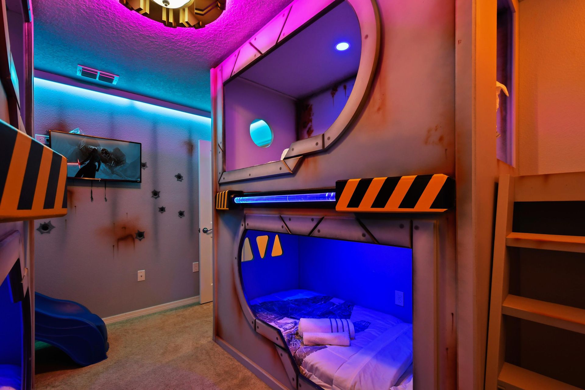 Immersive galaxy pod room with neon-lit bunks, starship vibes, and secret slide.