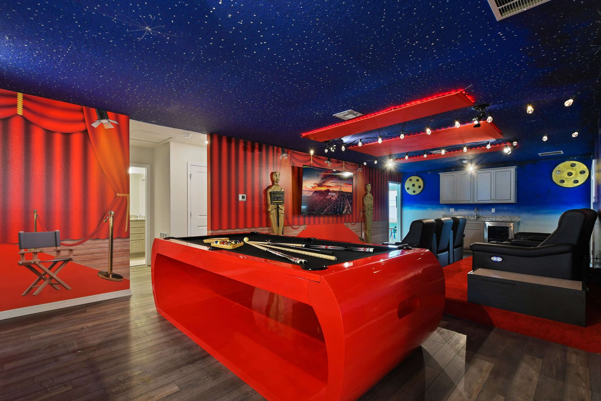 Hollywood glam theater room with red pool table, starry ceiling, and cinema seating.