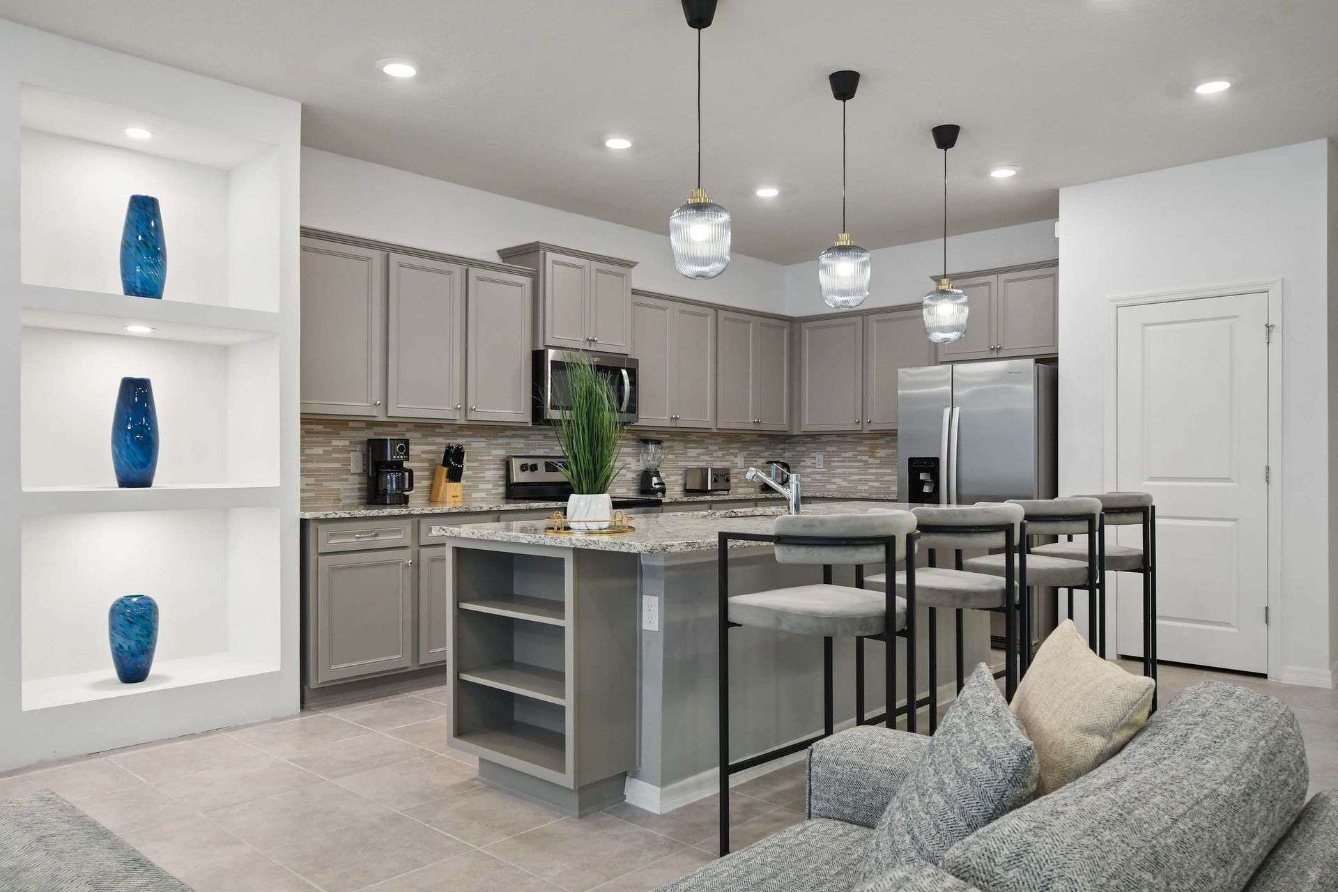 Contemporary kitchen with granite island, pendant lighting, and stainless steel.