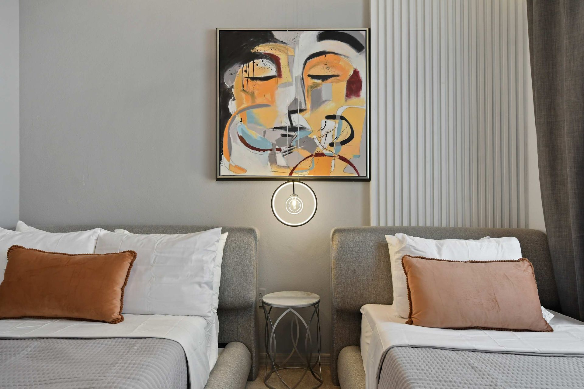 Cozy full and twin beds with modern art, soft lighting, and neutral textures.