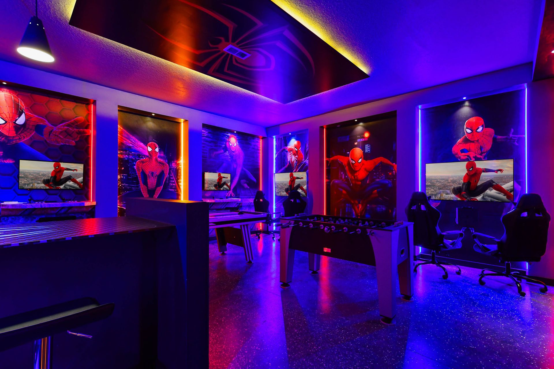 Spider-Verse gamer’s dream with foosball, consoles, arcade games, and bold lights.