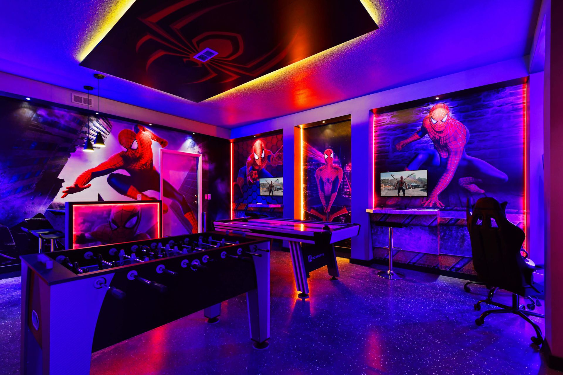 Action-packed Spider-Man game room with consoles, foosball, air hockey, and glow.