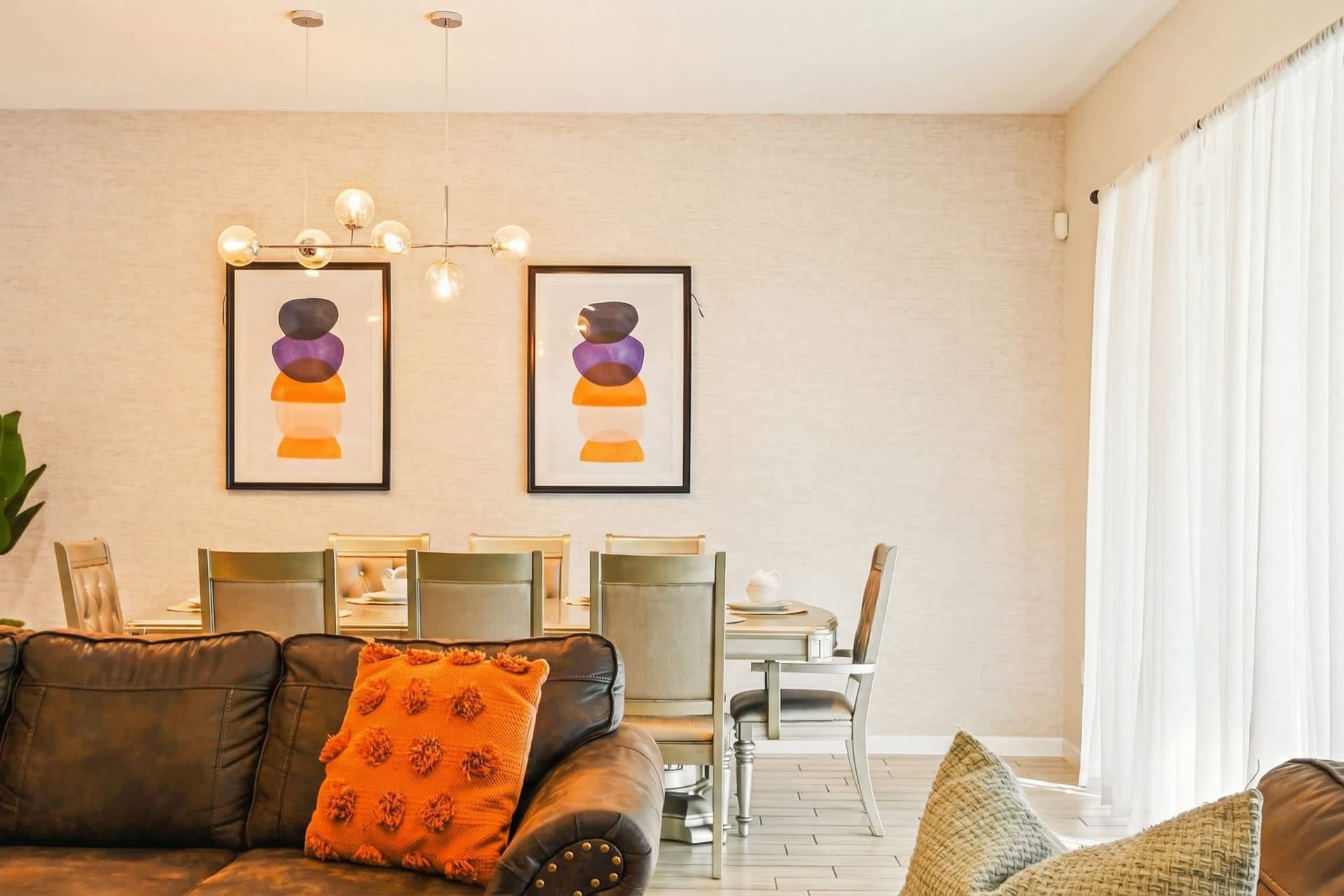 Elegant dining area with modern art, sleek lighting, and seating for eight.
