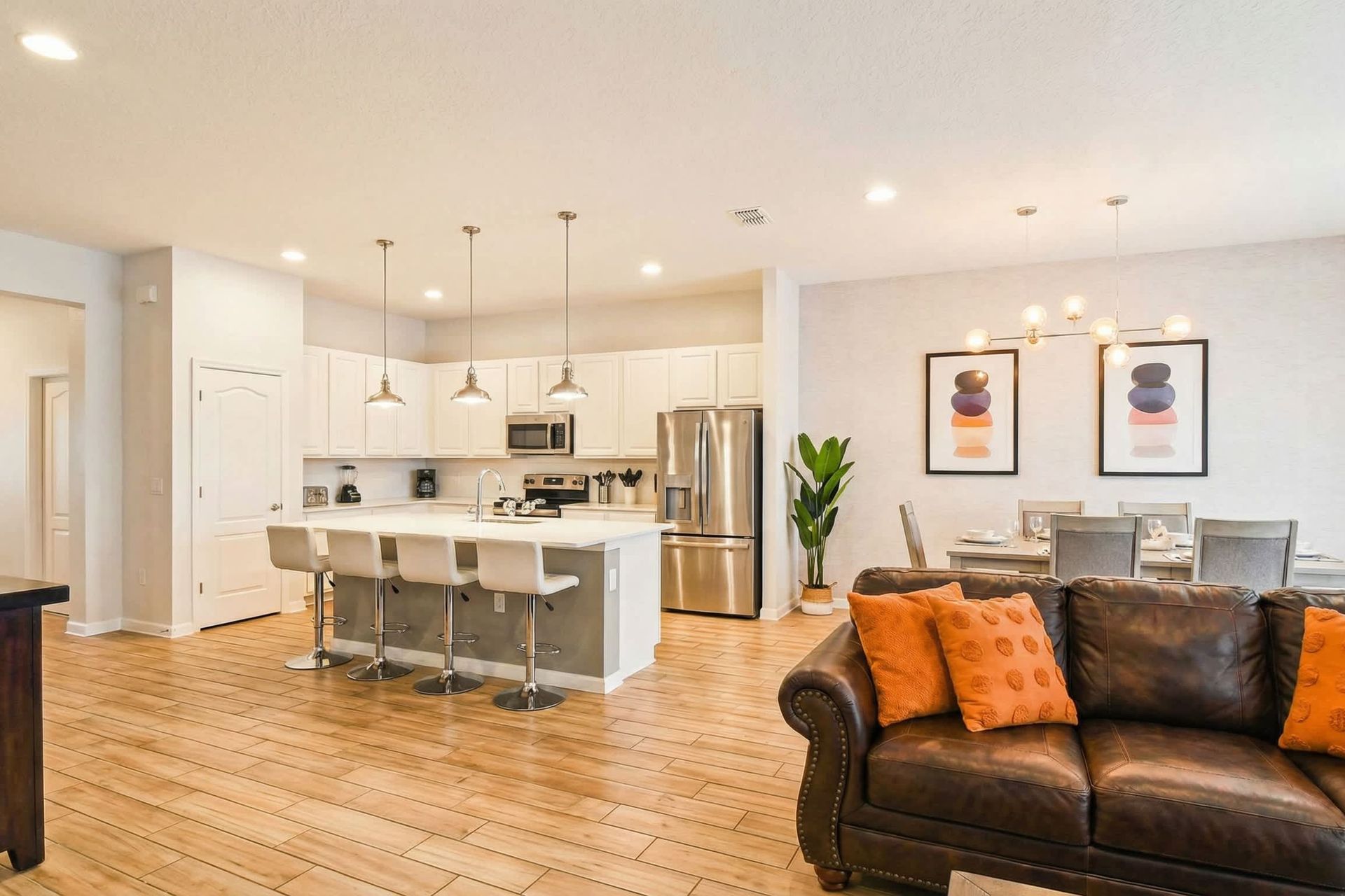 Fully equipped modern kitchen with island seating and open flow to dining area.
