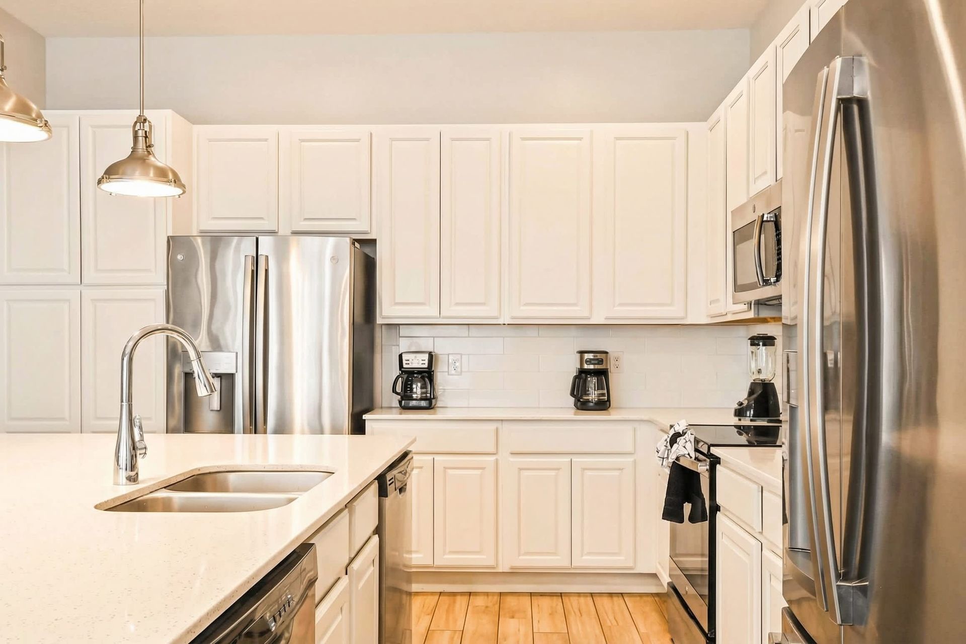 Spacious kitchen with double coffee makers, sleek appliances, and bright finishes.
