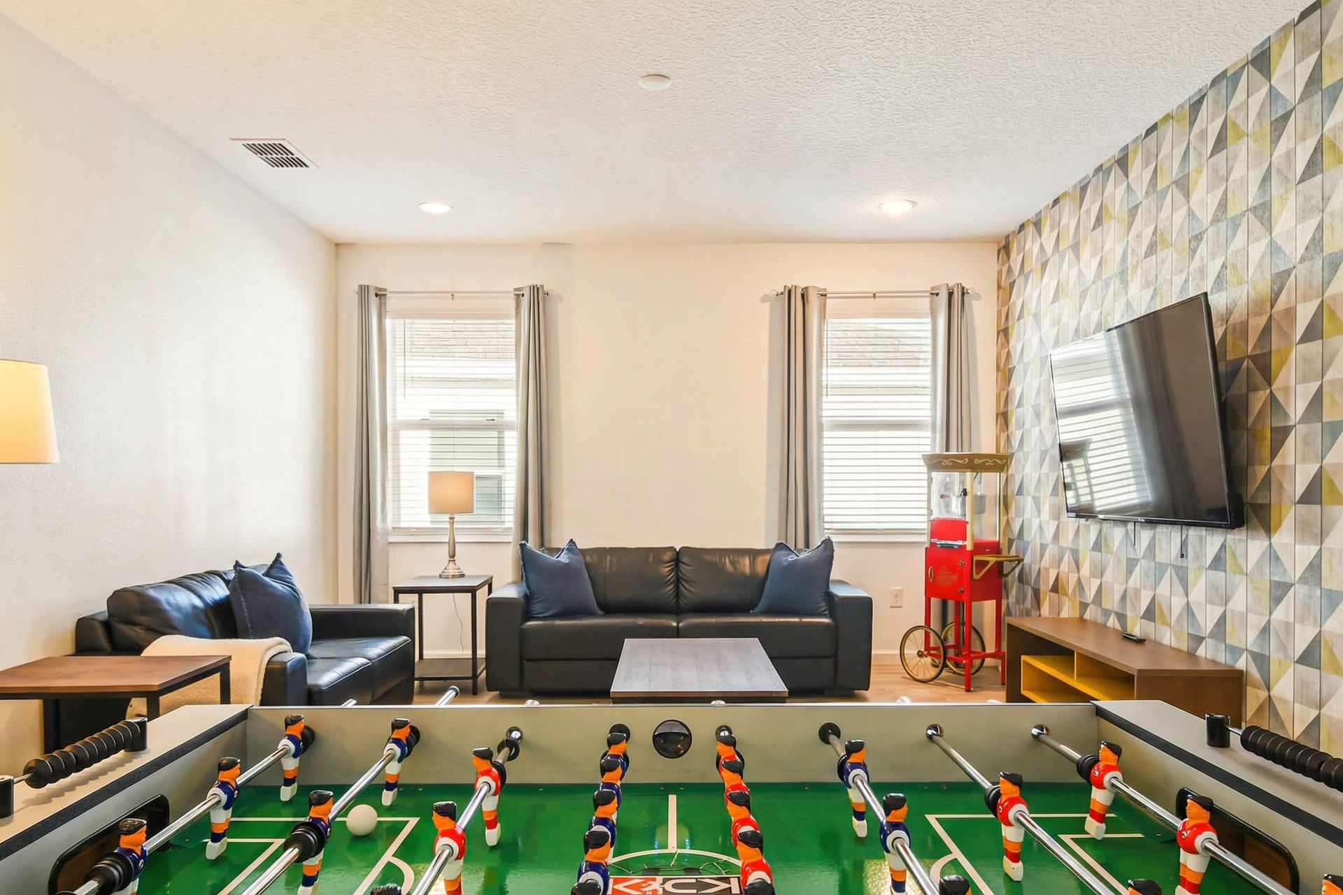 Enjoy quality time with family and friends in this cozy game room featuring a foosball table and comfortable seating.