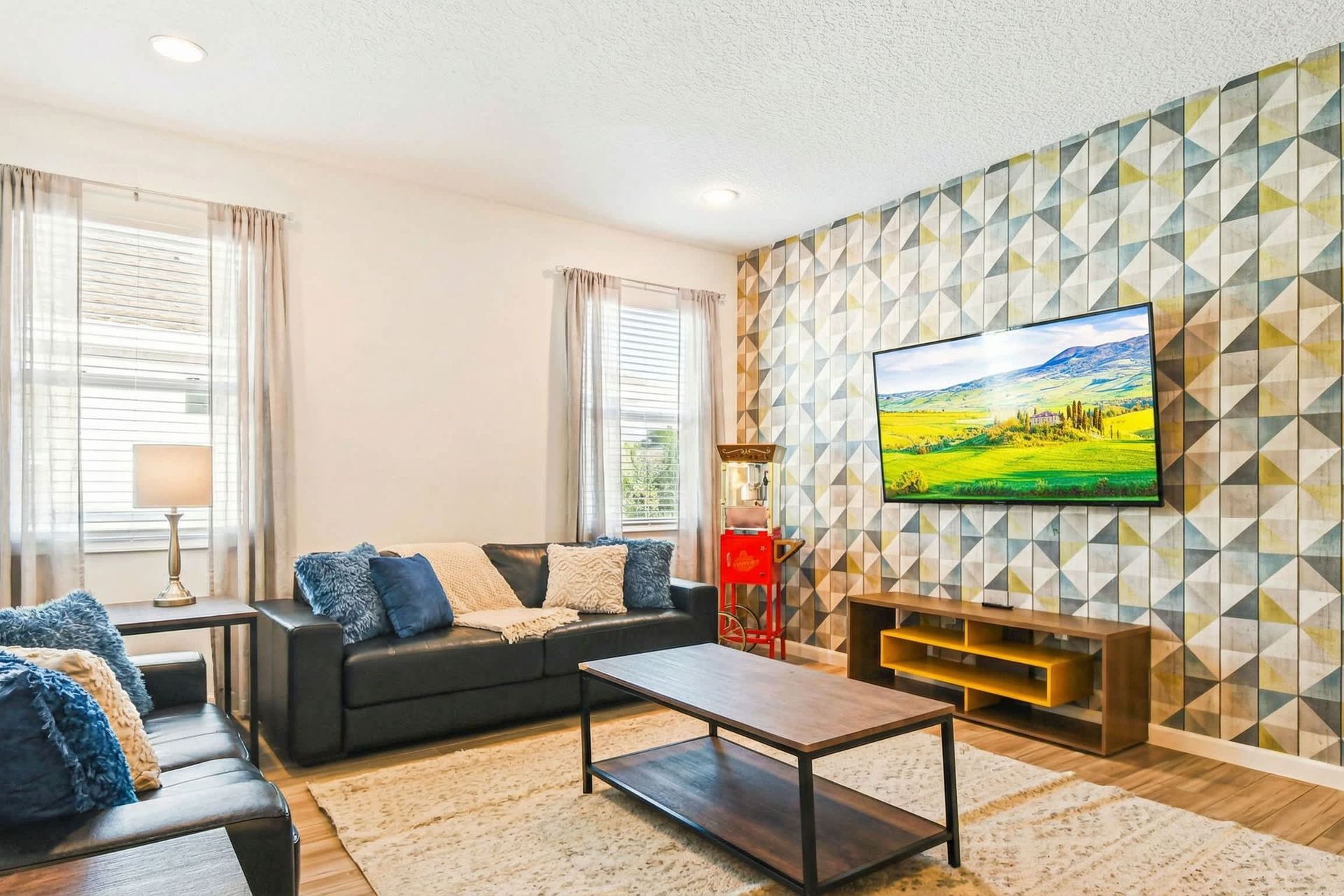 Cozy media room with bold accent wall, leather seating, and mounted smart TV.
