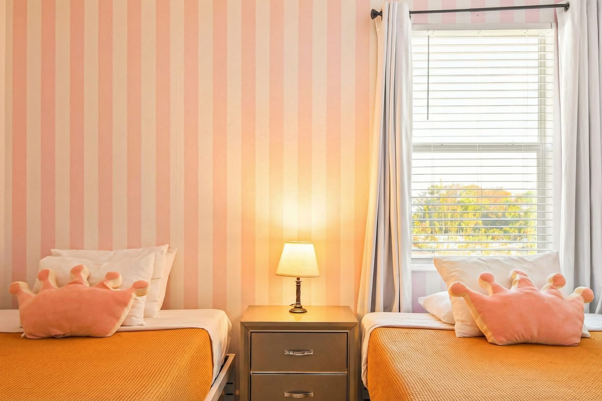 Charming princess-themed twin room with playful wallpaper and cozy bedding.
