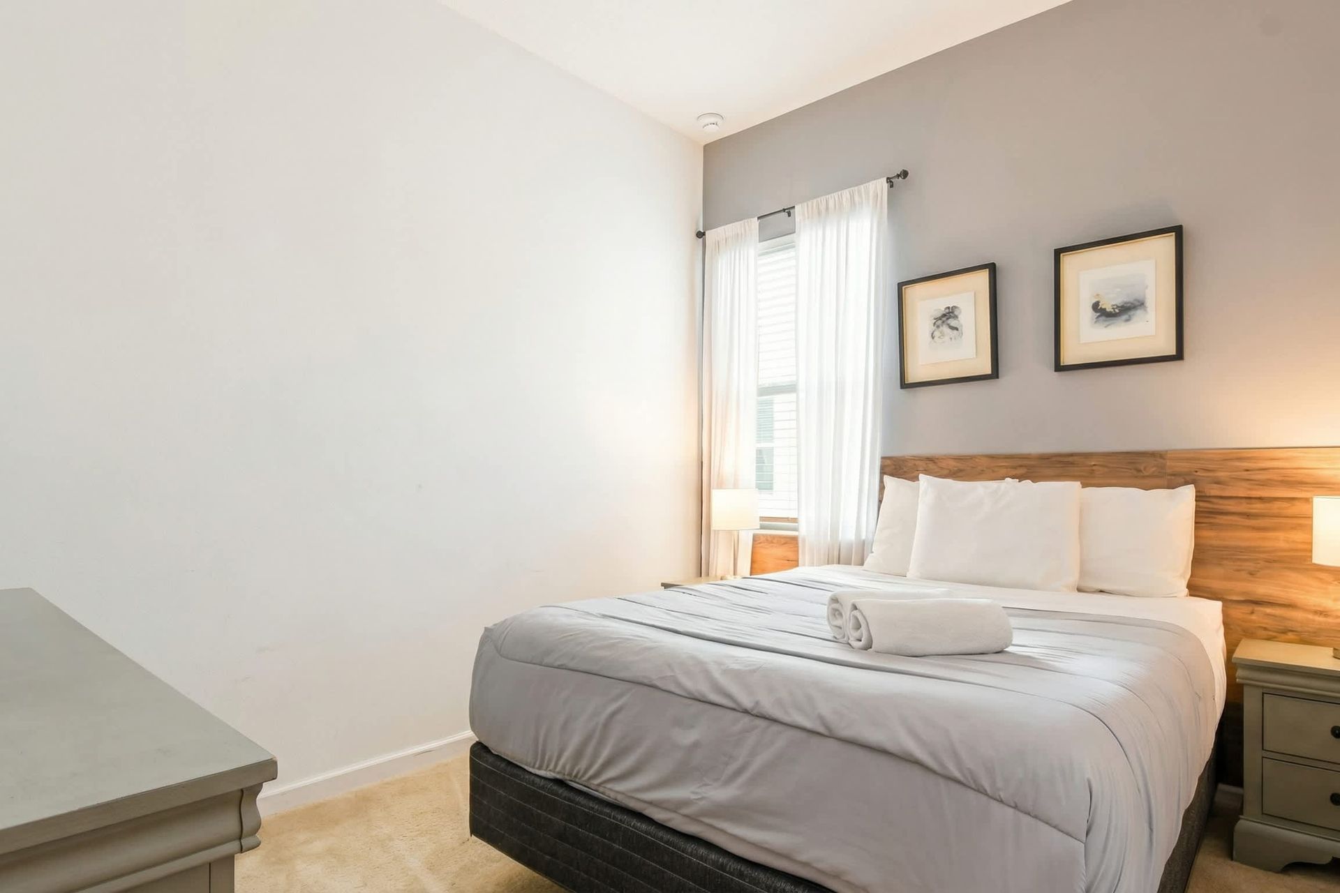 Tranquil bedroom with cozy queen bed, natural wood accents, and soft lighting.

