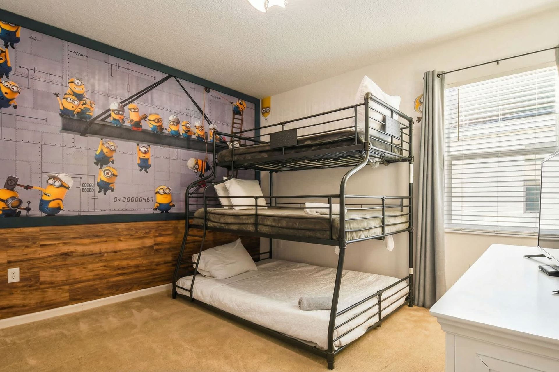 Playful kids’ room with themed wall mural, bunk bed, and extra floor mattress.

