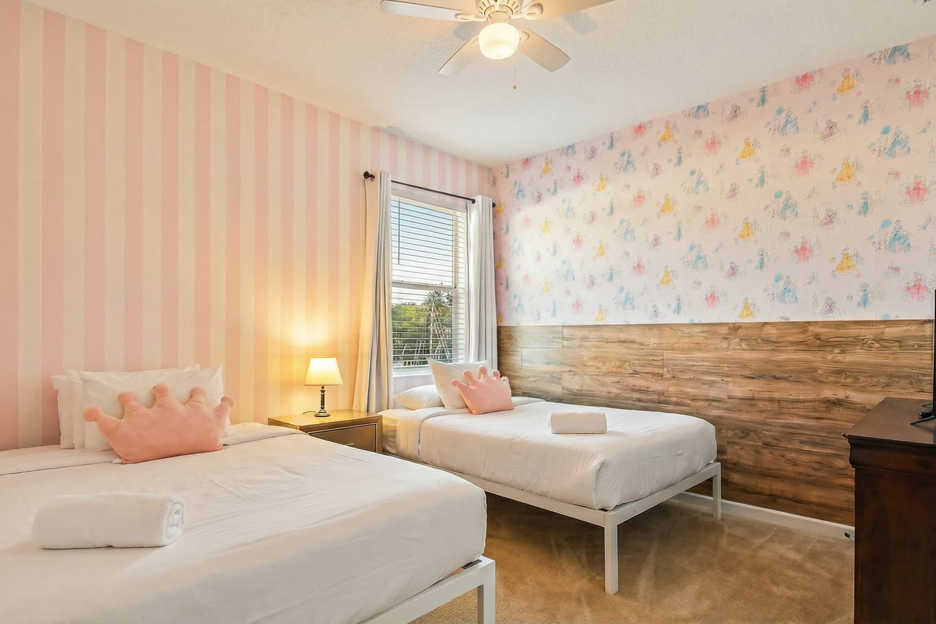 Charming princess-themed twin room with playful wallpaper and cozy bedding.
