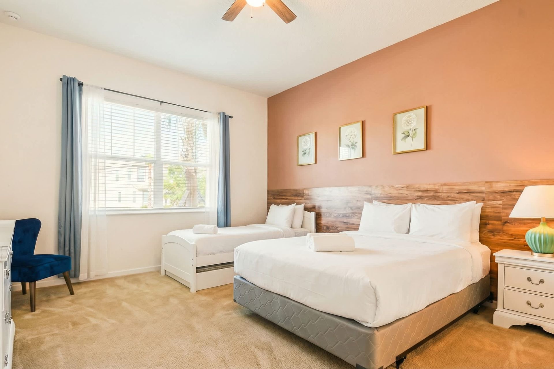 Inviting twin room with warm tones, wood accents, and a large sunny window.

