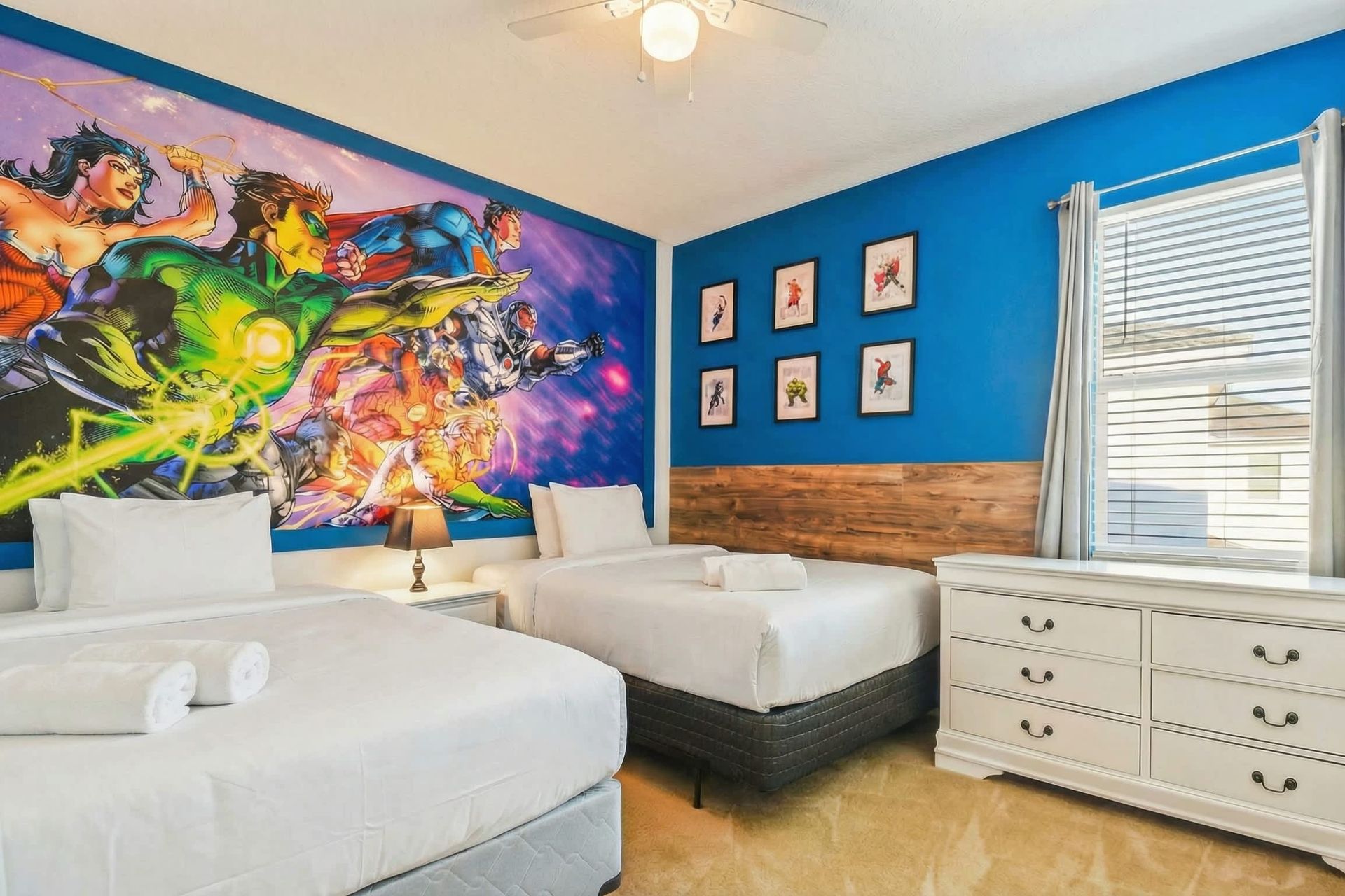 Bold superhero-themed room with twin beds and vibrant comic-style wall art.
