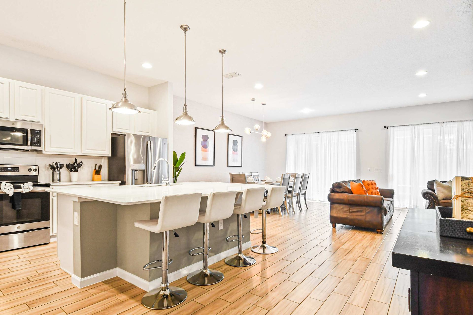 Fully equipped modern kitchen with island seating and open flow to dining area.
