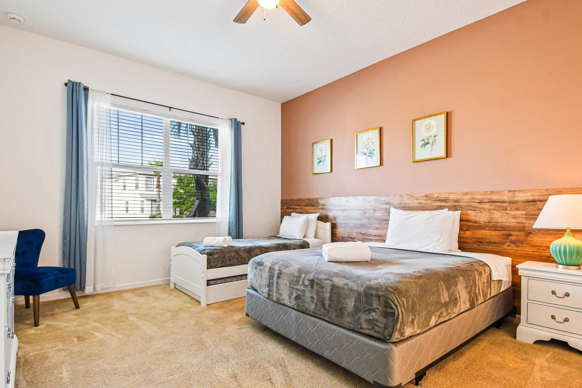 Inviting twin room with warm tones, wood accents, and a large sunny window.
