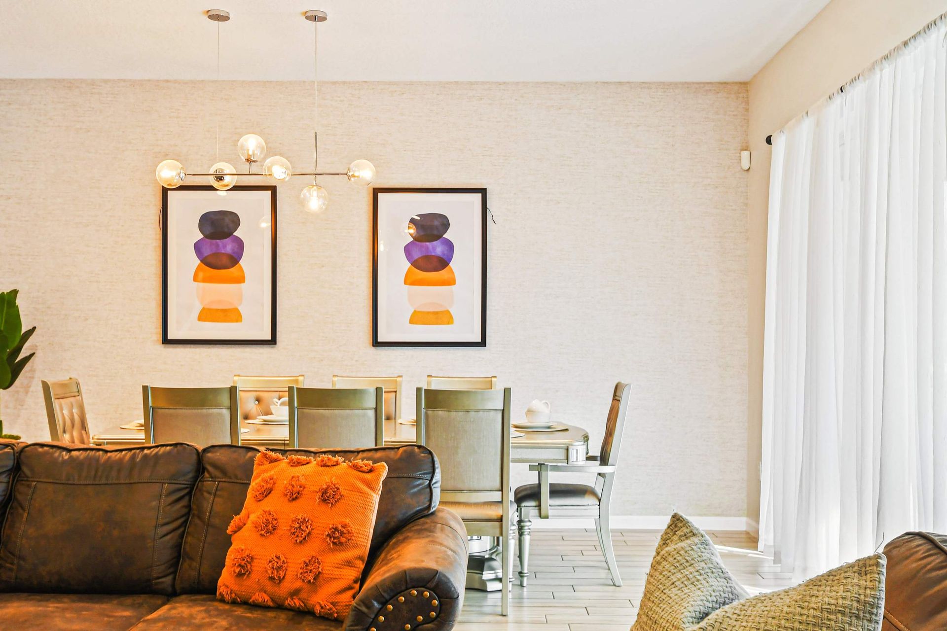 Elegant dining area with modern art, sleek lighting, and seating for eight.
