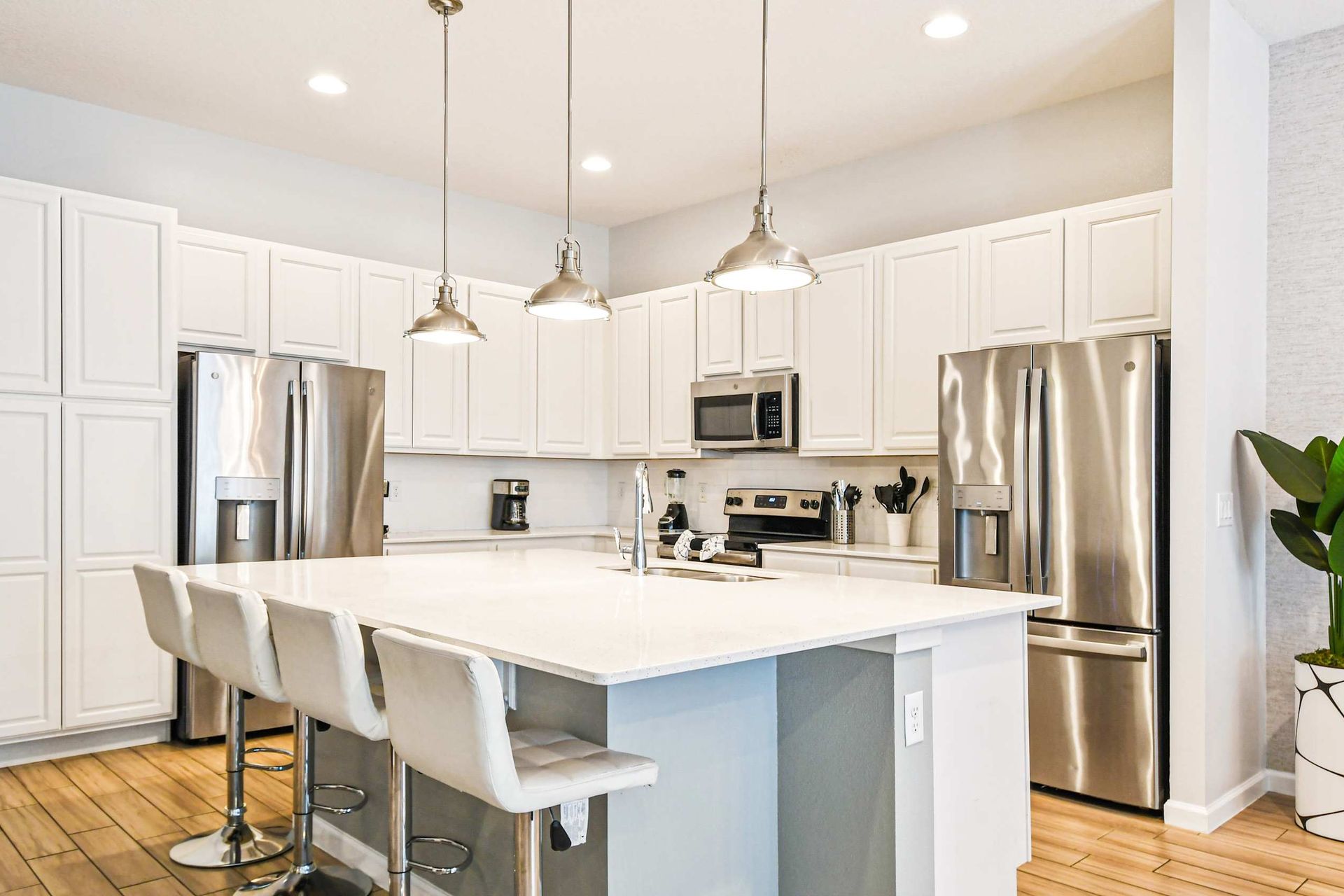 Bright gourmet kitchen with large island, stainless appliances, and ample seating.
