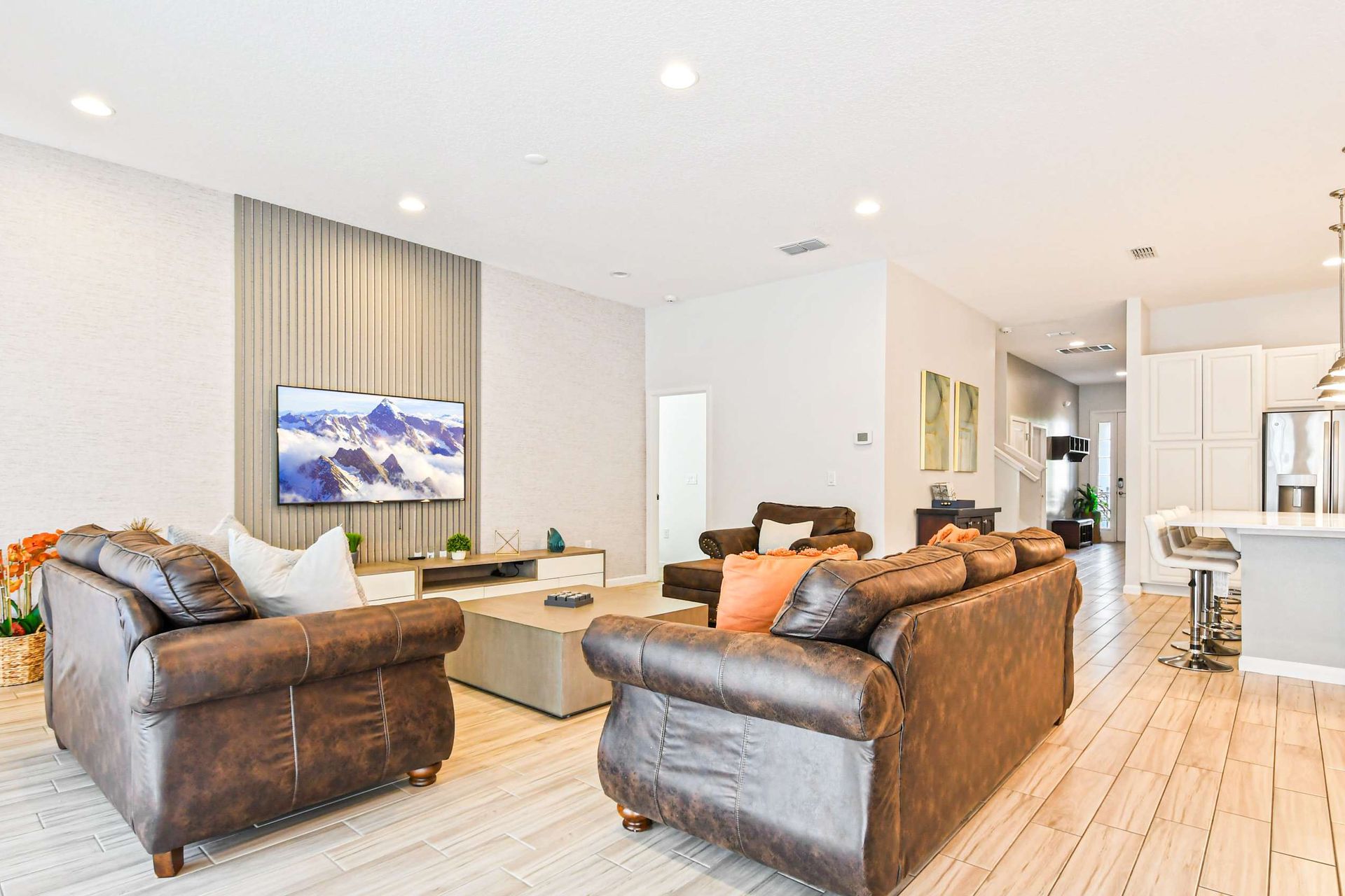 Bright open layout with comfy seating, modern kitchen, and stylish wood accents.
