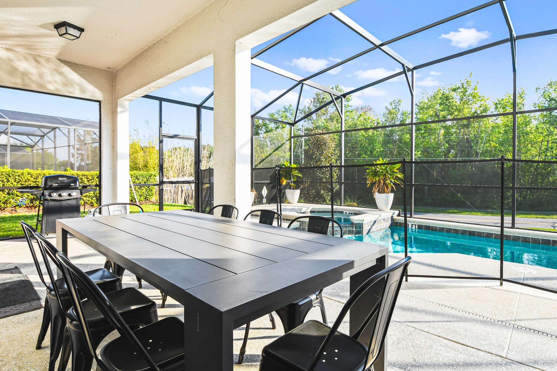 Screened patio with pool, BBQ grill, dining for ten, and peaceful forest views.
