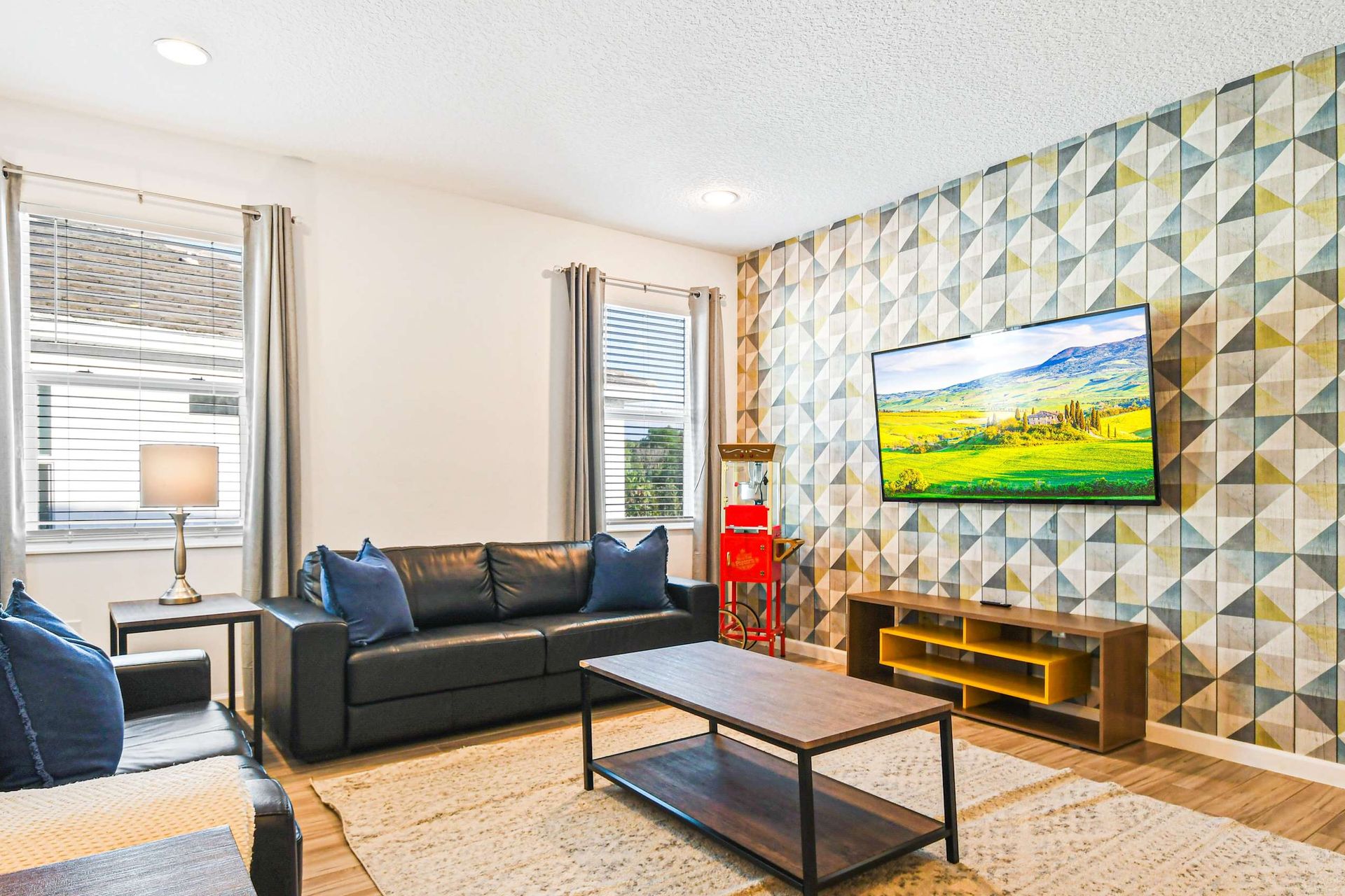 Cozy media room with bold accent wall, leather seating, and mounted smart TV.
