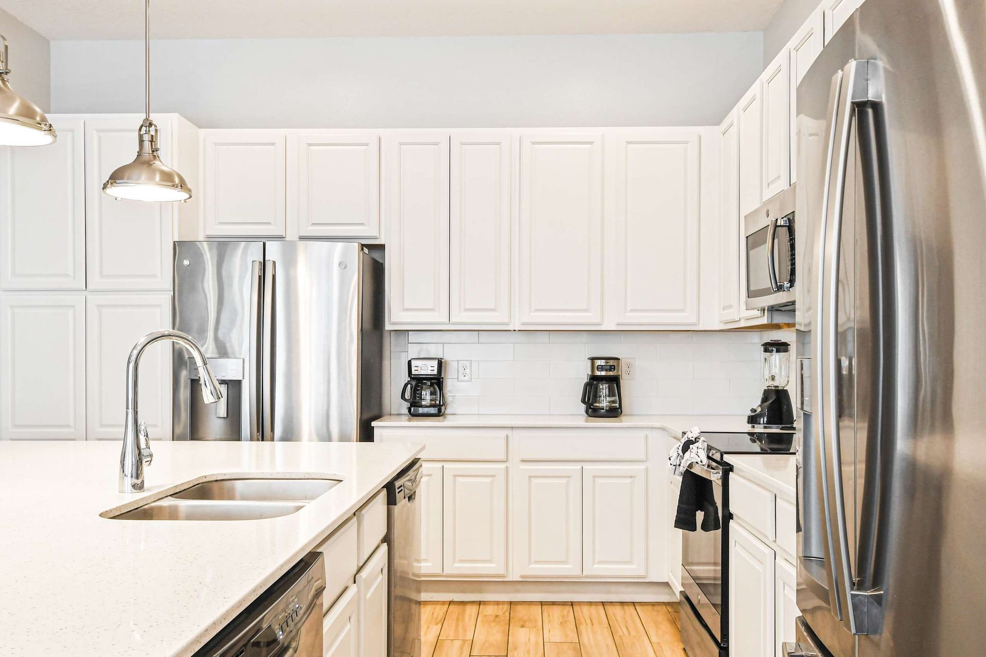 Spacious kitchen with double coffee makers, sleek appliances, and bright finishes.
