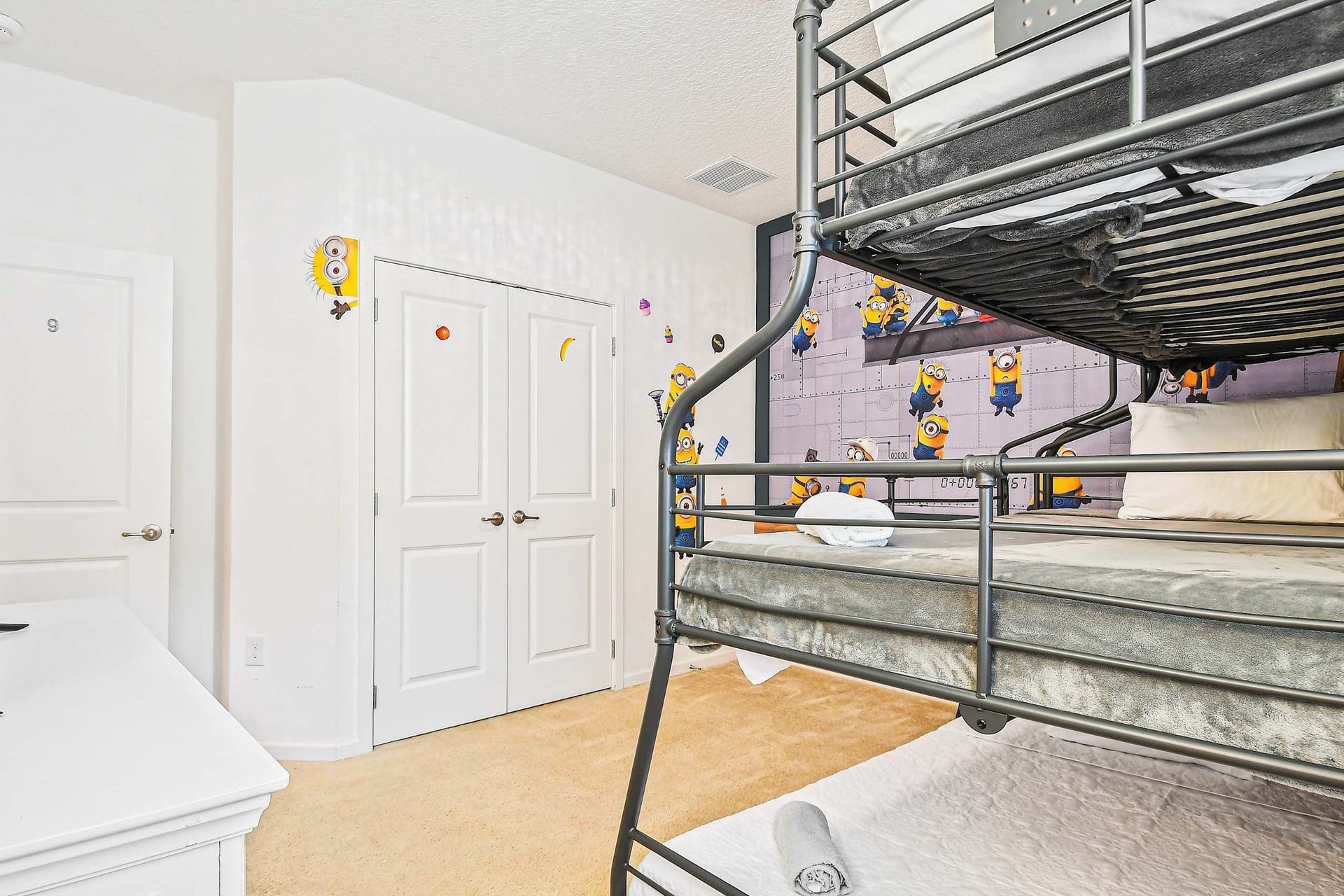 Playful kids’ room with themed wall mural, bunk bed, and extra floor mattress.
