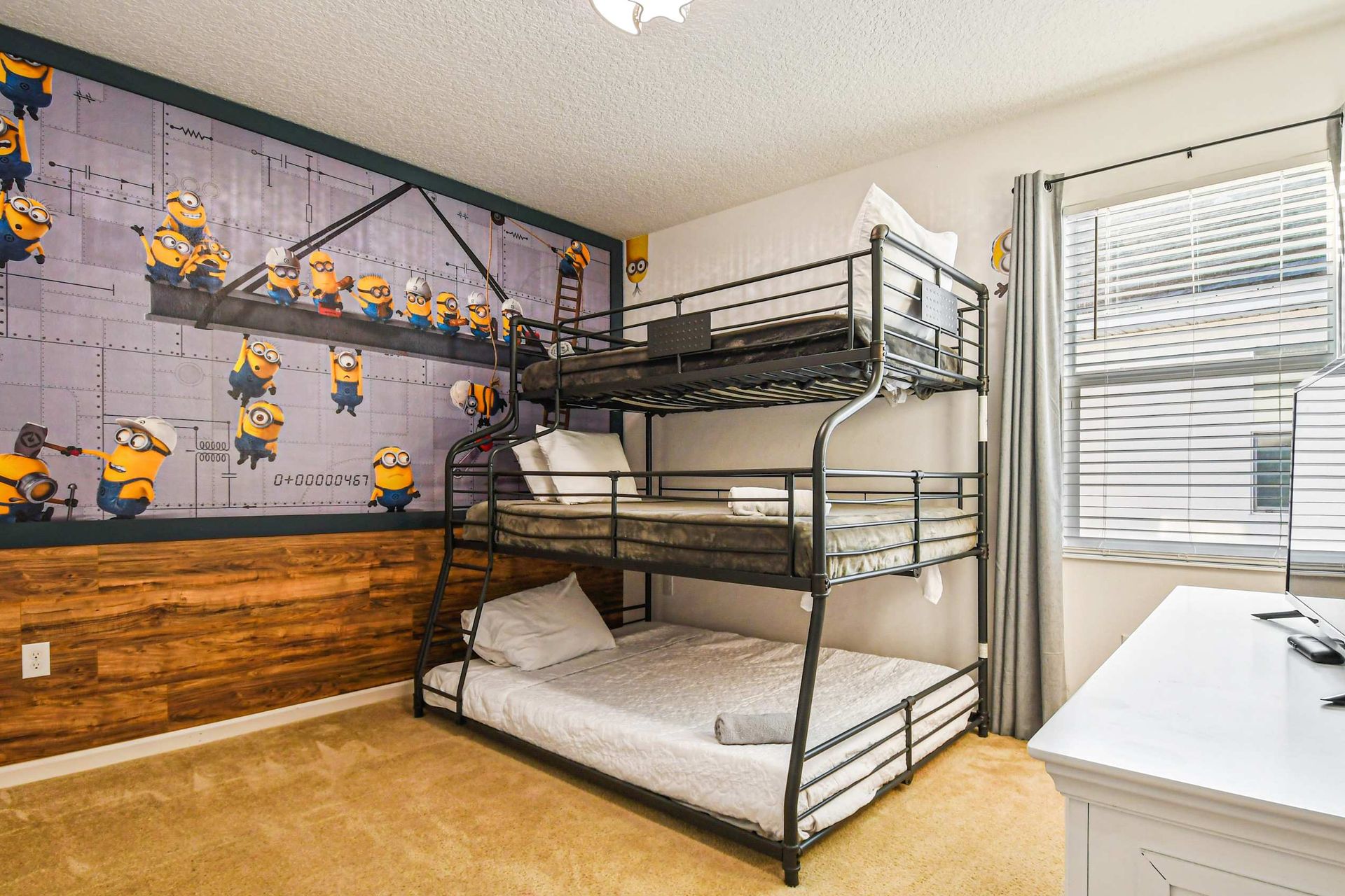 Playful kids’ room with themed wall mural, bunk bed, and extra floor mattress.
