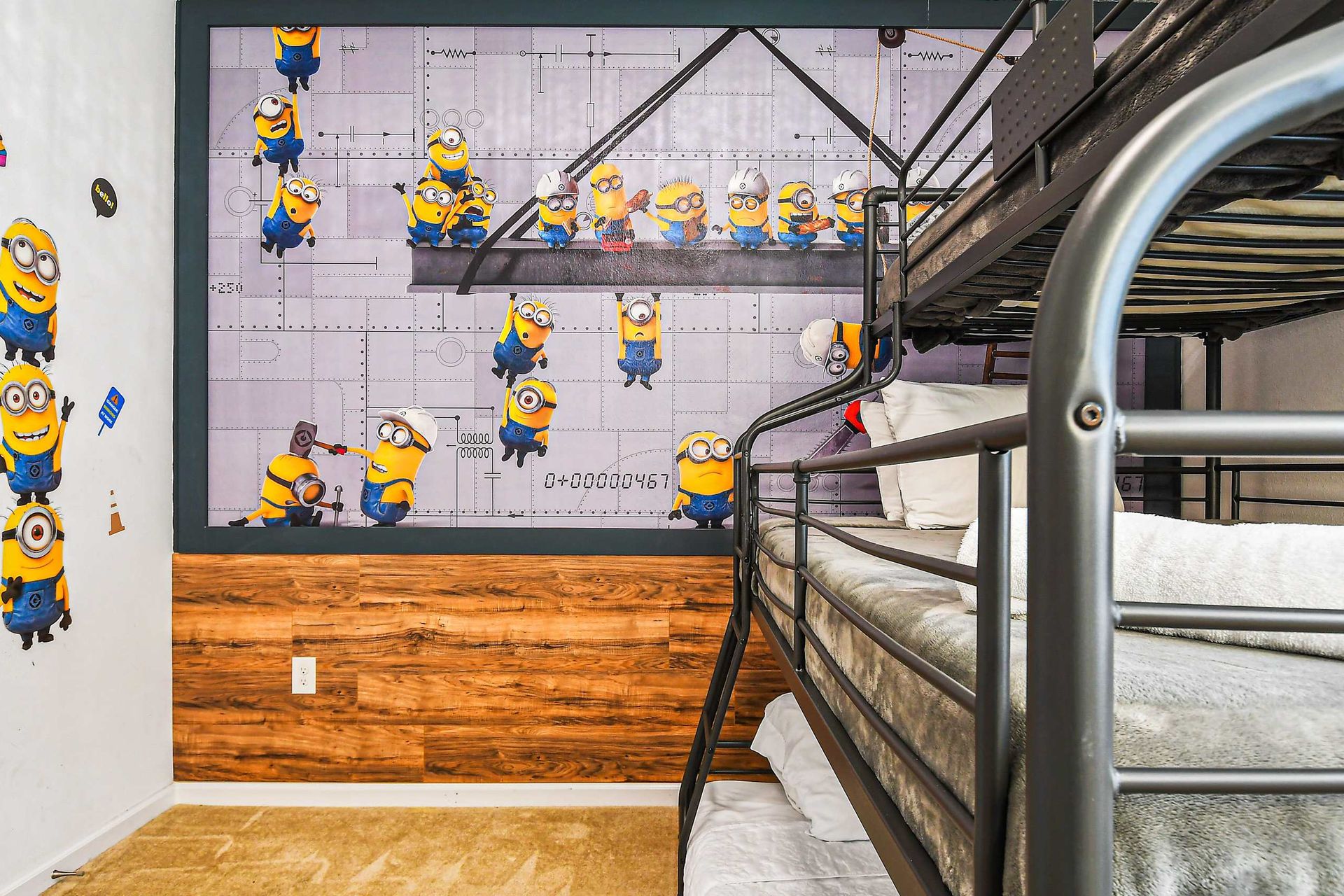 Playful kids’ room with themed wall mural, bunk bed, and extra floor mattress.
