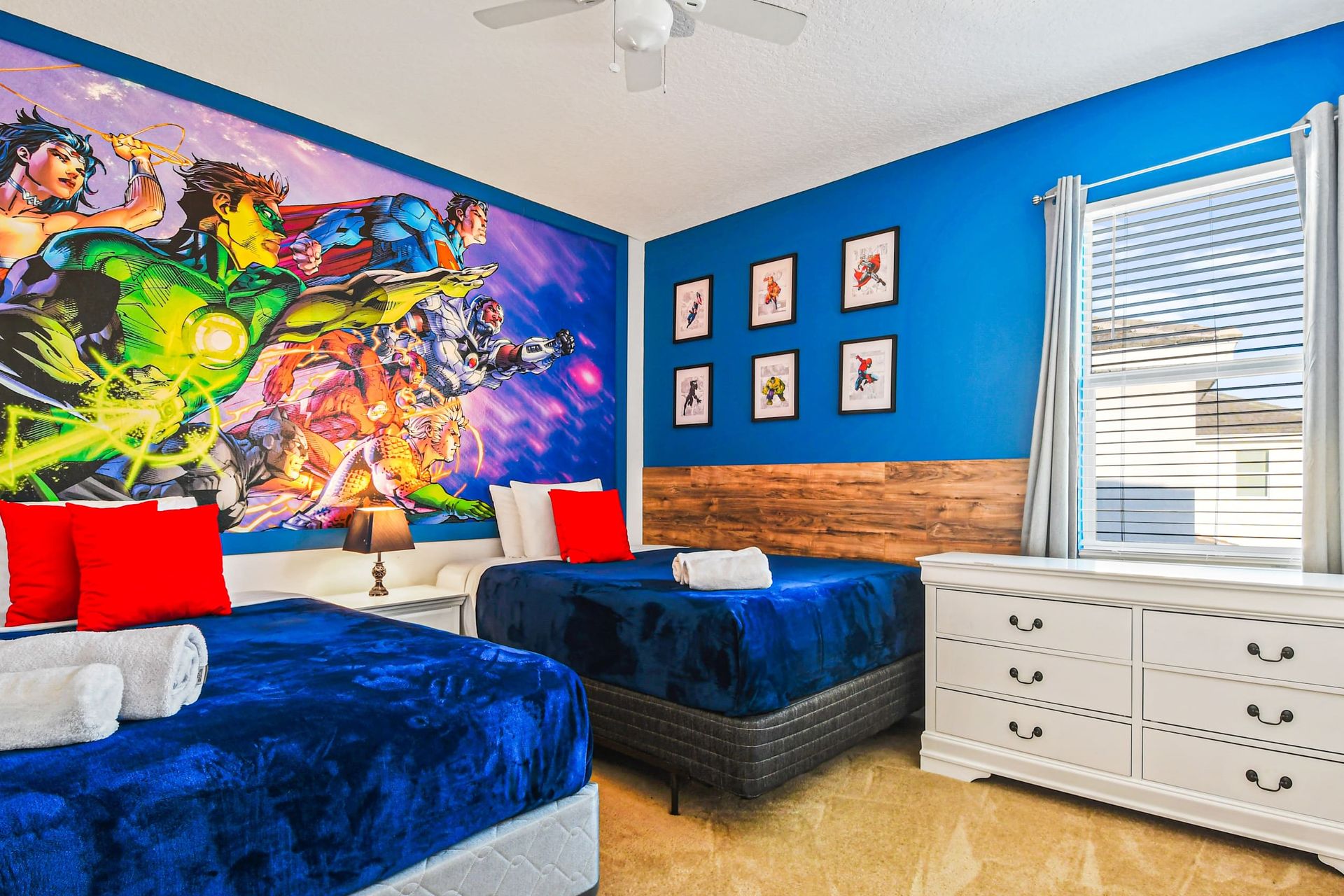 Bold superhero-themed room with twin beds and vibrant comic-style wall art.
