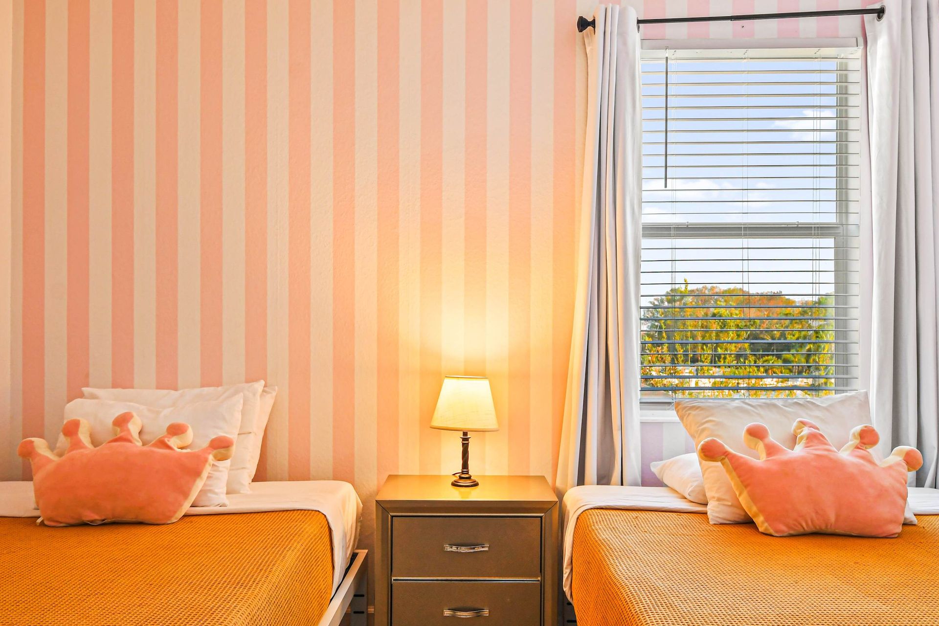 Charming princess-themed twin room with playful wallpaper and cozy bedding.
