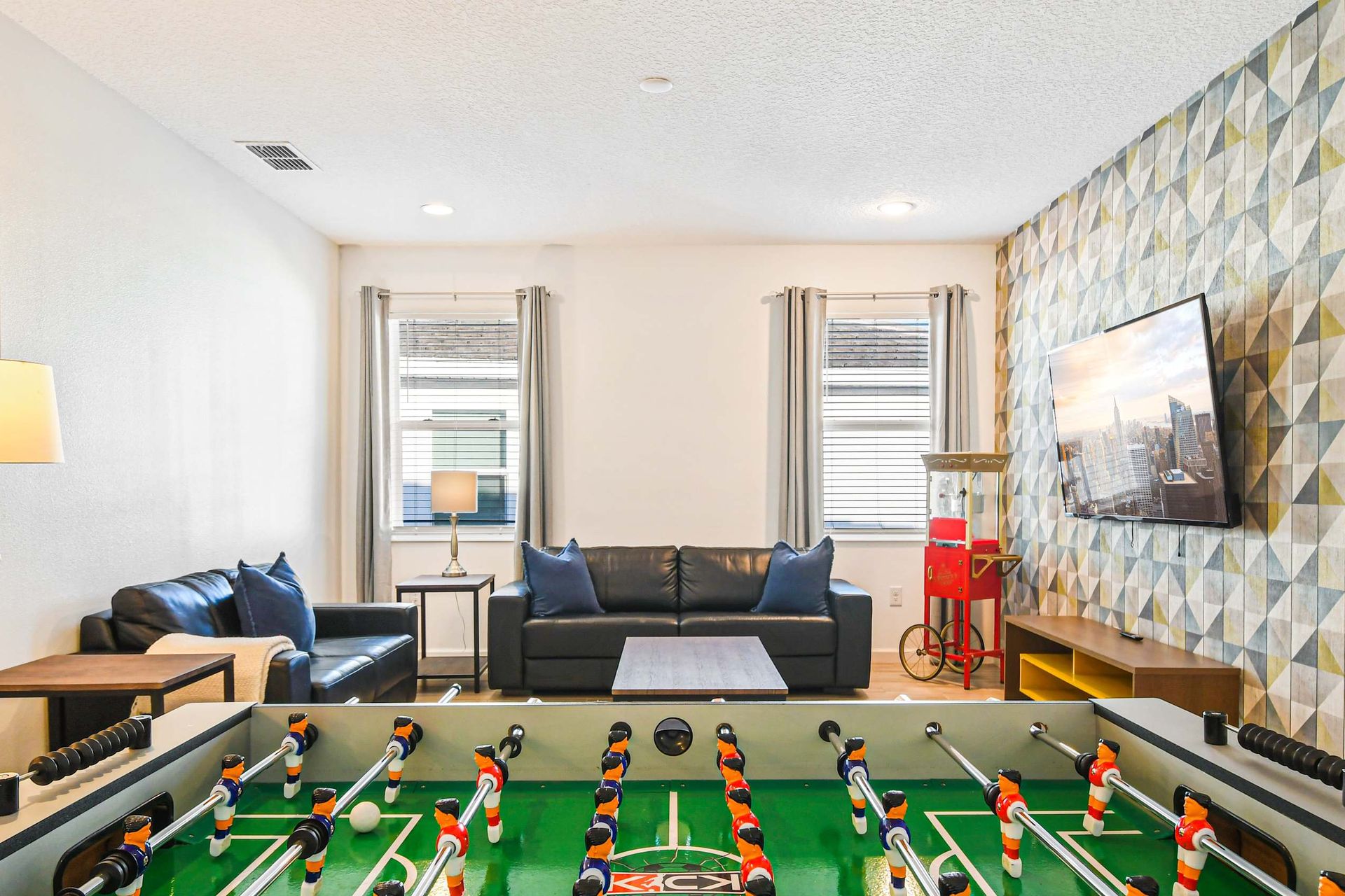 Enjoy quality time with family and friends in this cozy game room featuring a foosball table and comfortable seating.