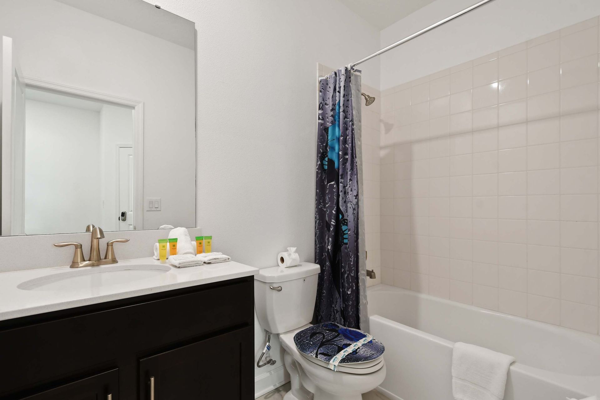 Modern full bath with a fun ocean-themed touch, fresh towels, and essentials.