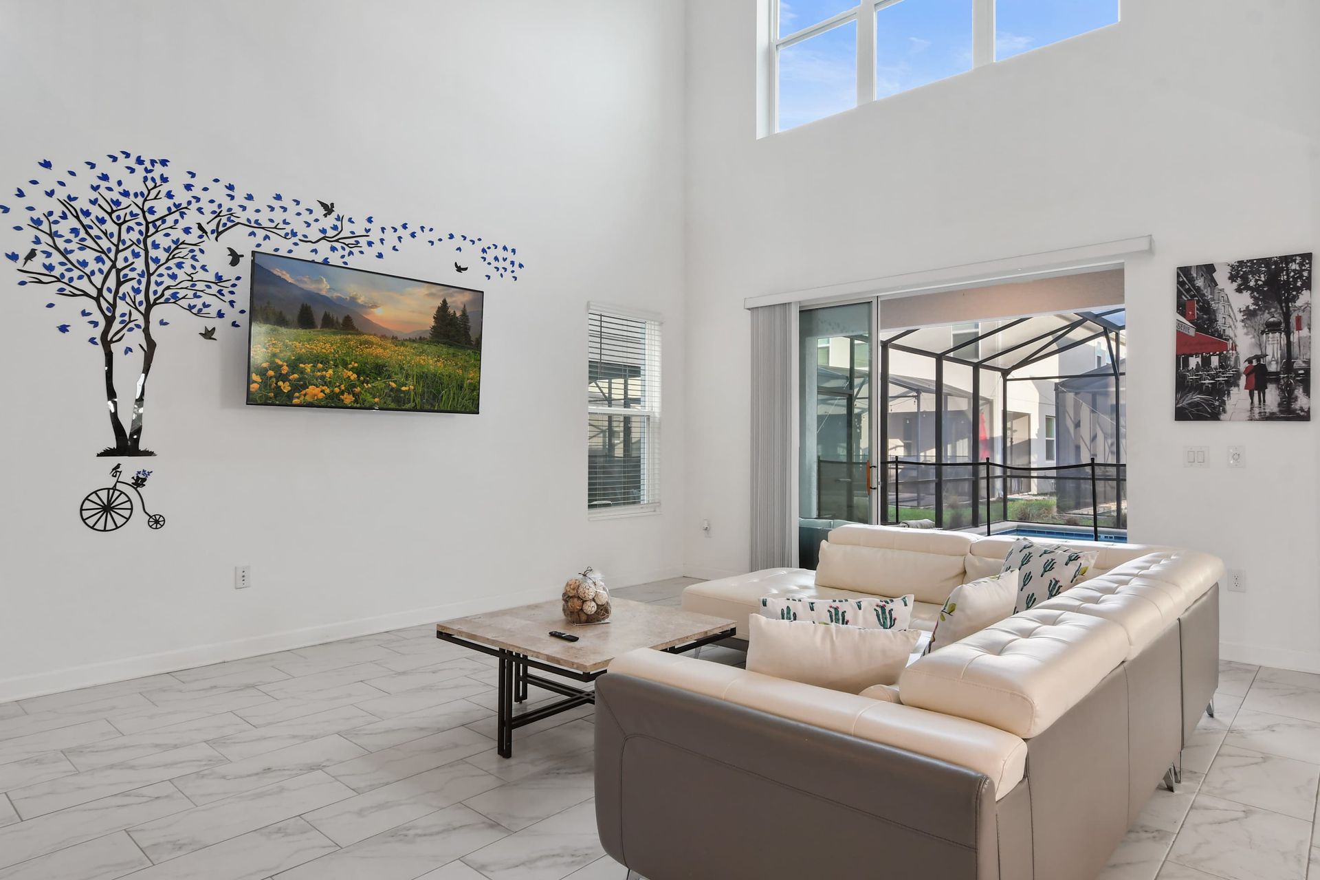 Bright and airy living space with wall art, smart TV, and direct pool access.
