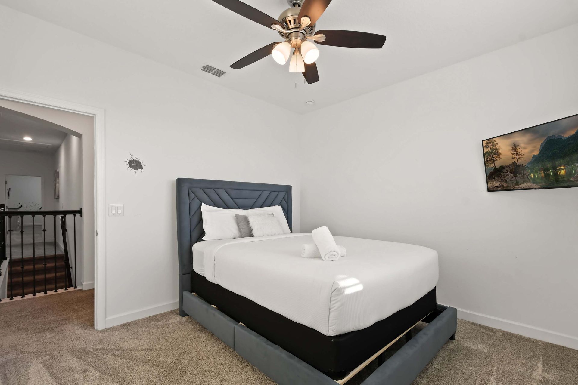 Chic and cozy room with a plush bed, soft lighting, and a mounted smart TV.