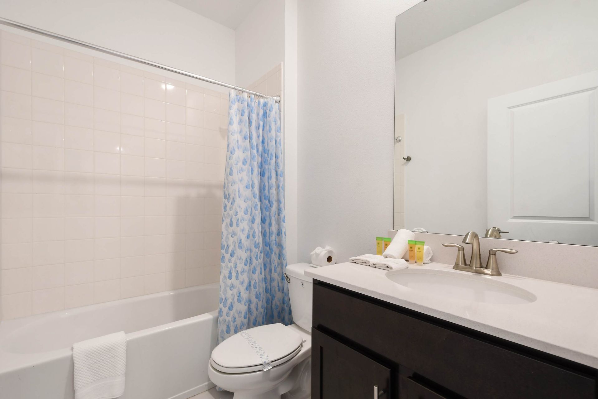 Clean and simple full bathroom with a tub-shower combo and fresh essentials.