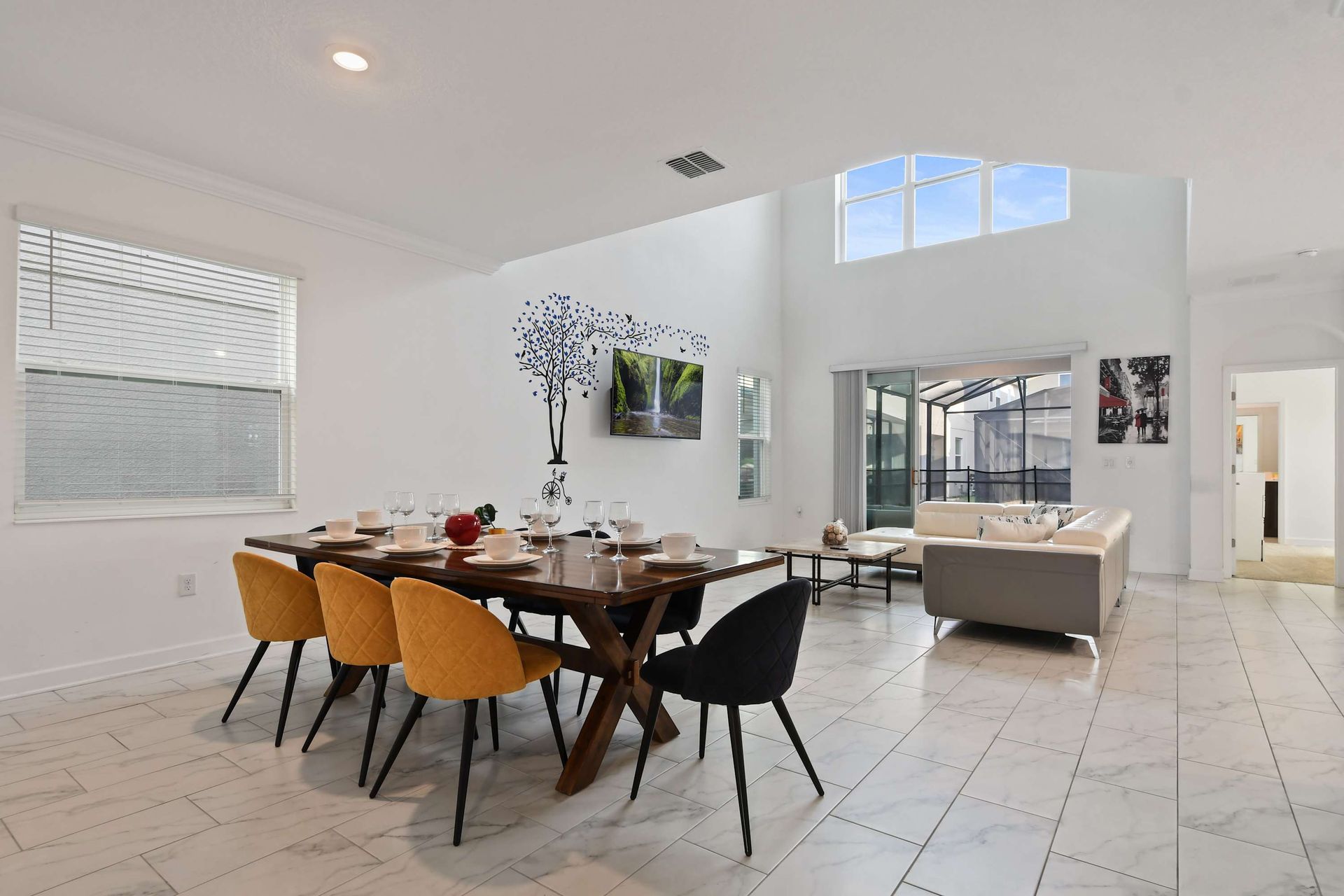 Stylish open dining and living area with high ceilings and access to the pool patio.