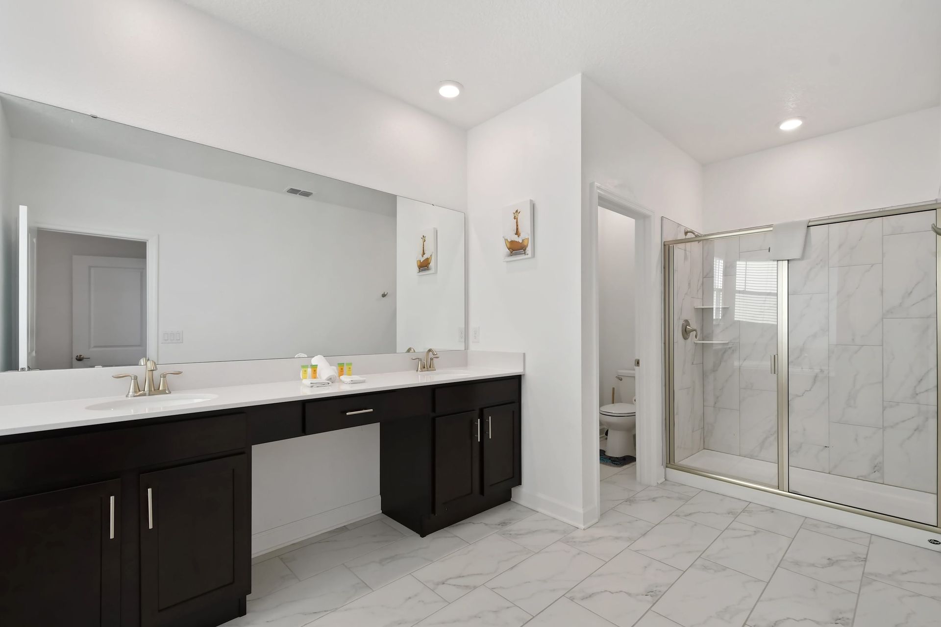 Luxurious master bath with dual sinks, a spacious walk-in shower, and vanity area.