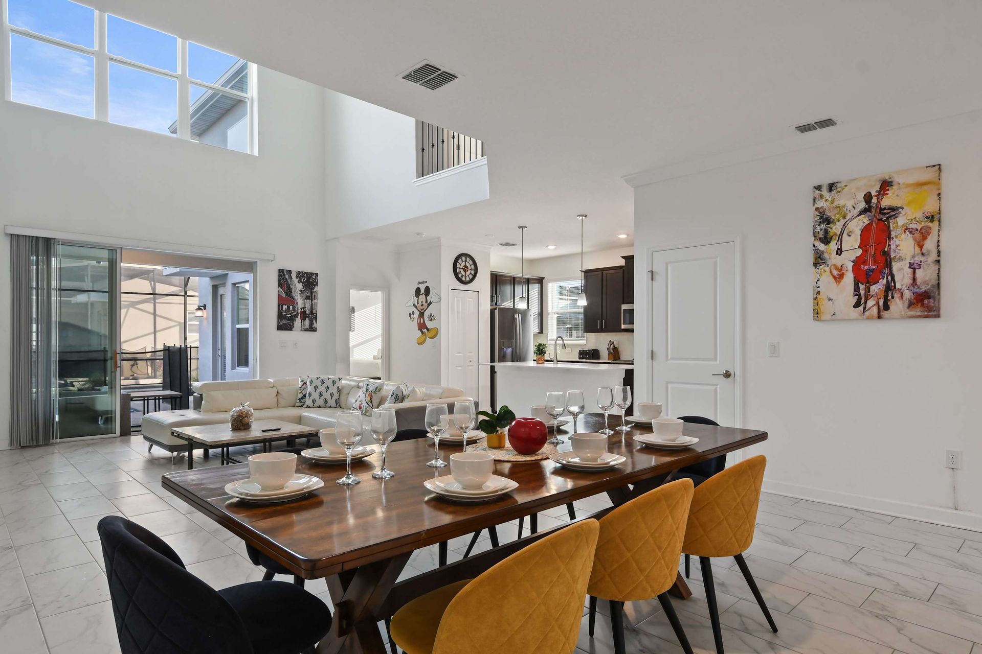 Open-concept kitchen, dining, and living space with vibrant decor and natural light.