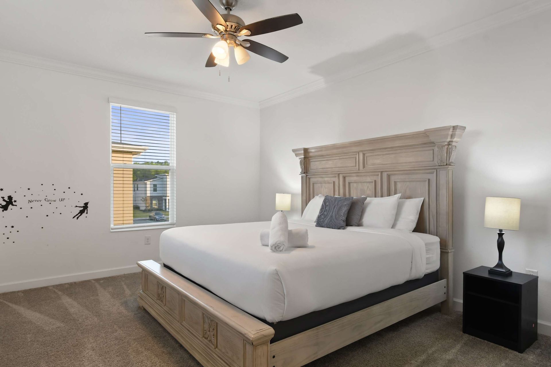 Spacious and elegant bedroom with a grand bed and charming wall art detail.