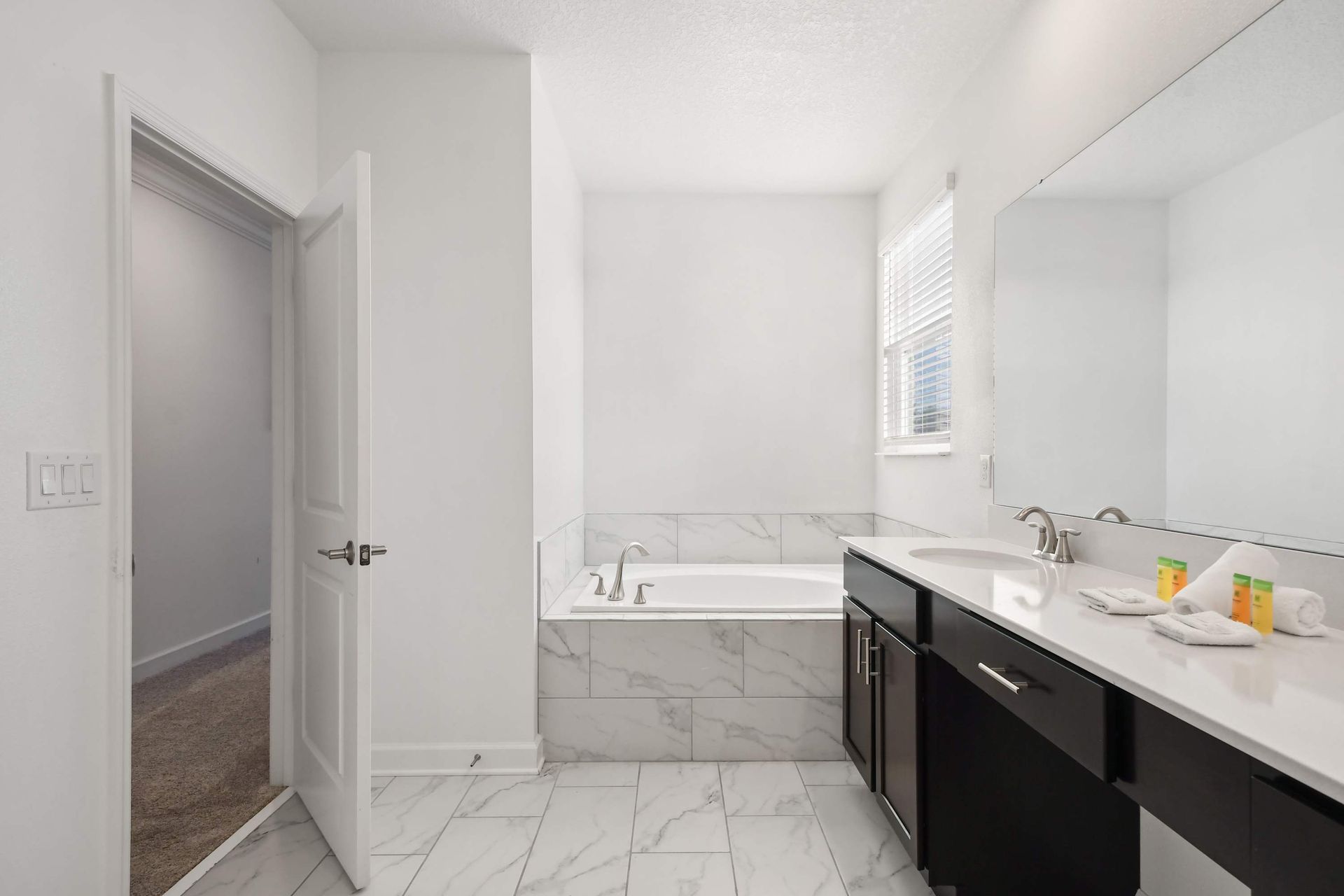 Elegant bathroom with a soaking tub, large vanity, and bright natural lighting.