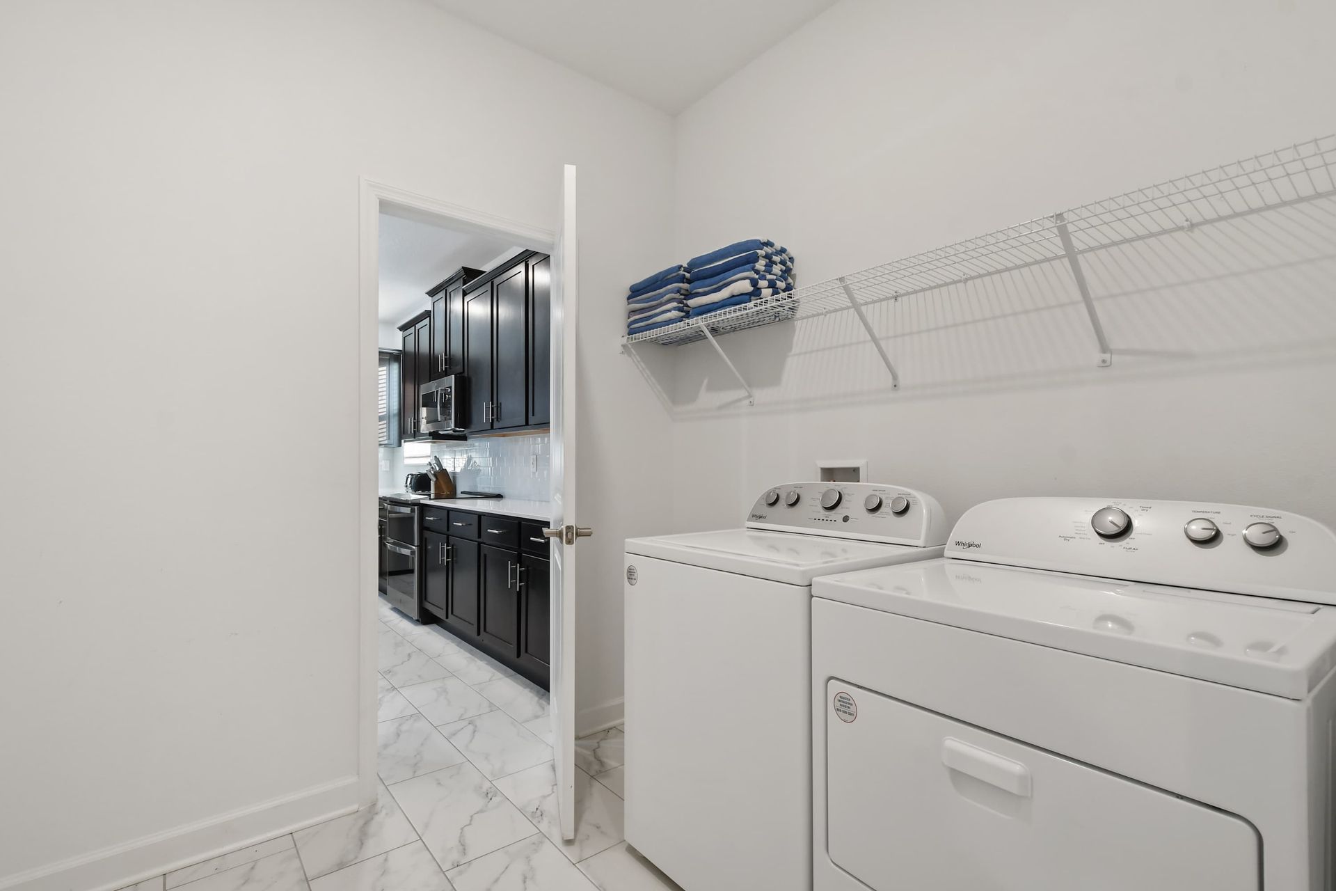 Convenient in-home laundry with washer, dryer, and fresh towels ready for use.