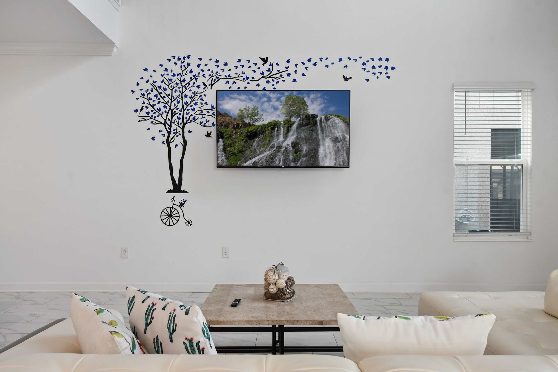 Chic lounge space with wall art, cozy seating, and a mounted smart TV for relaxing.