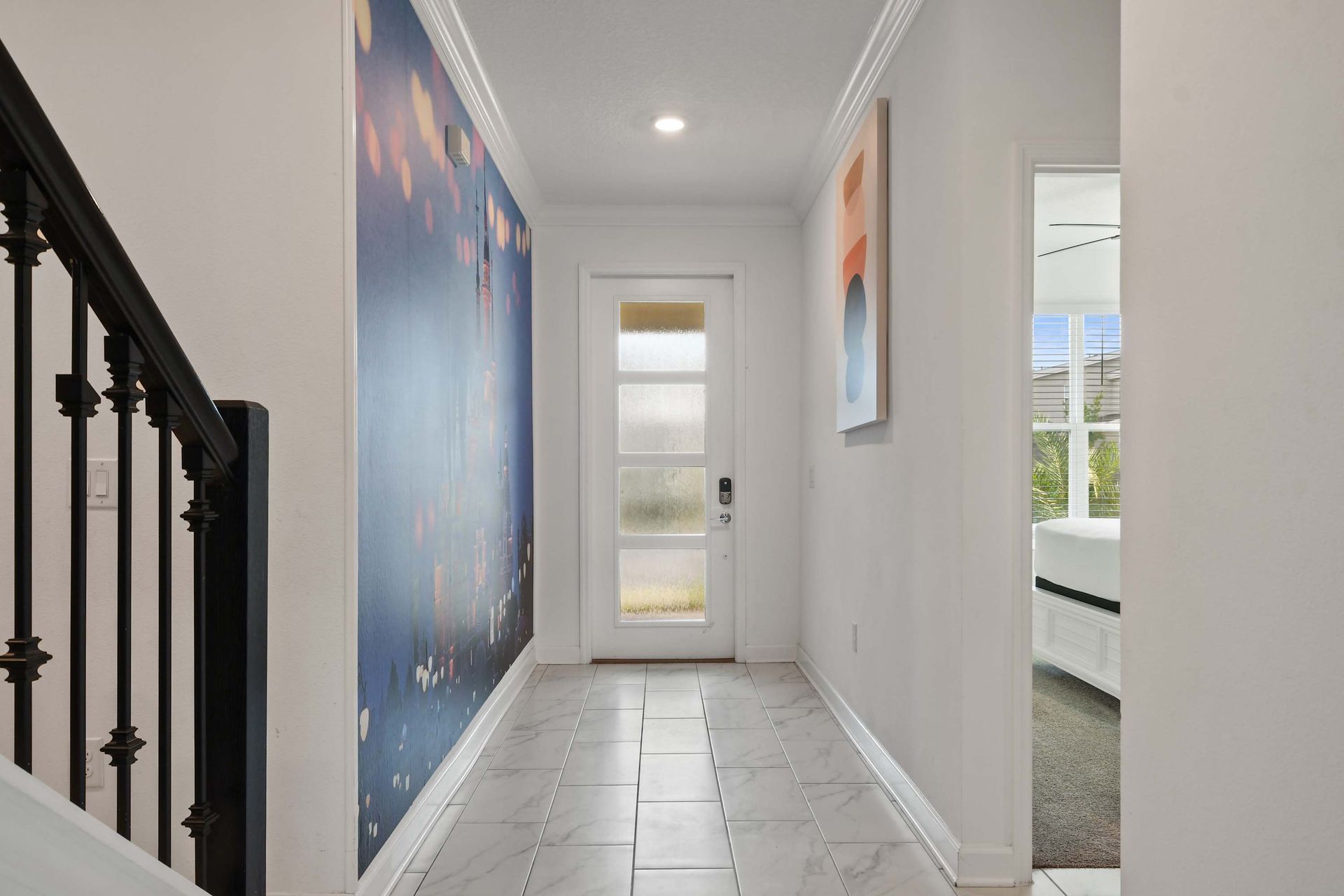 Charming entryway with magical mural, modern art, and a view into a bright suite.
