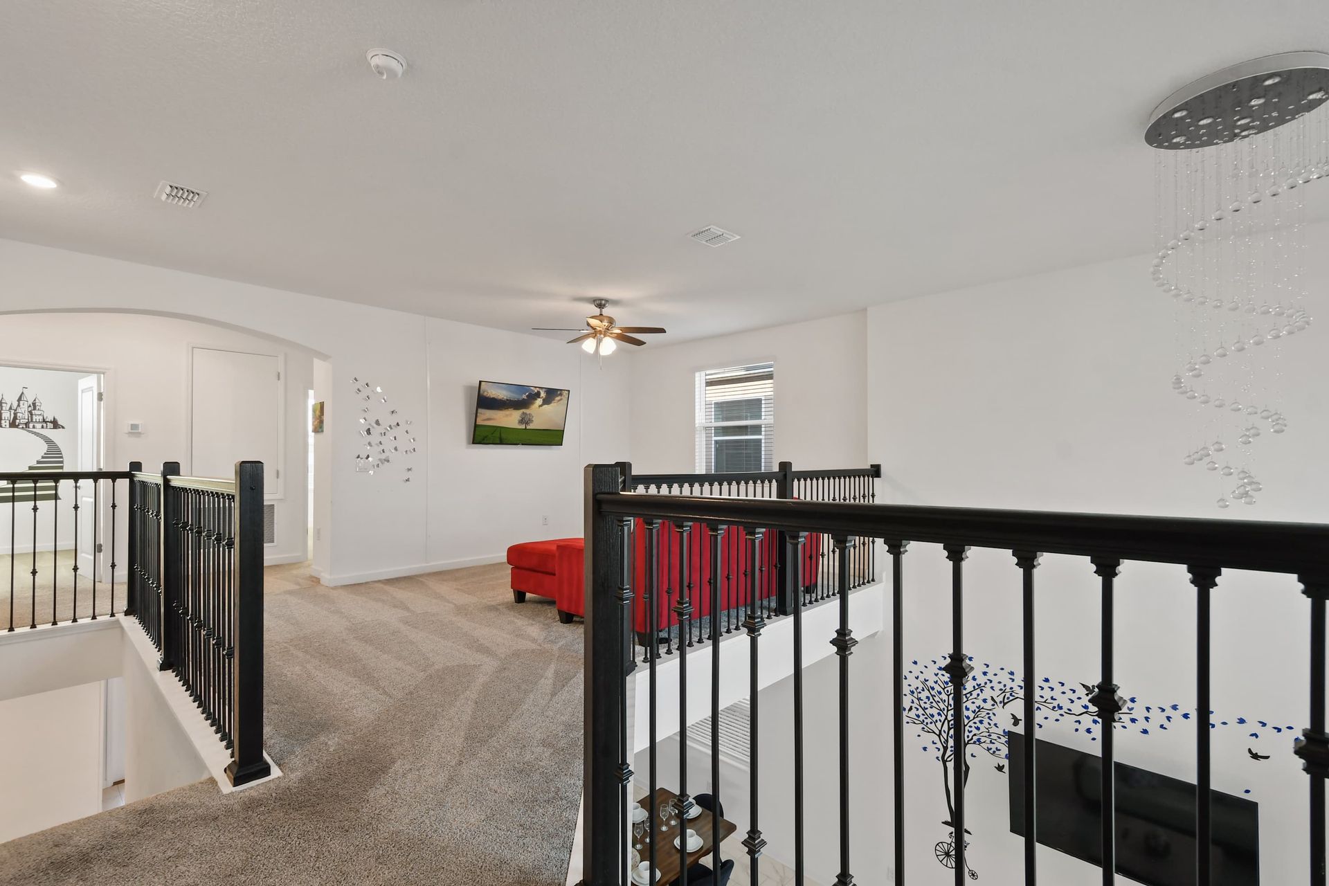 Spacious upstairs loft with cozy seating, smart TV, and artistic wall accents.