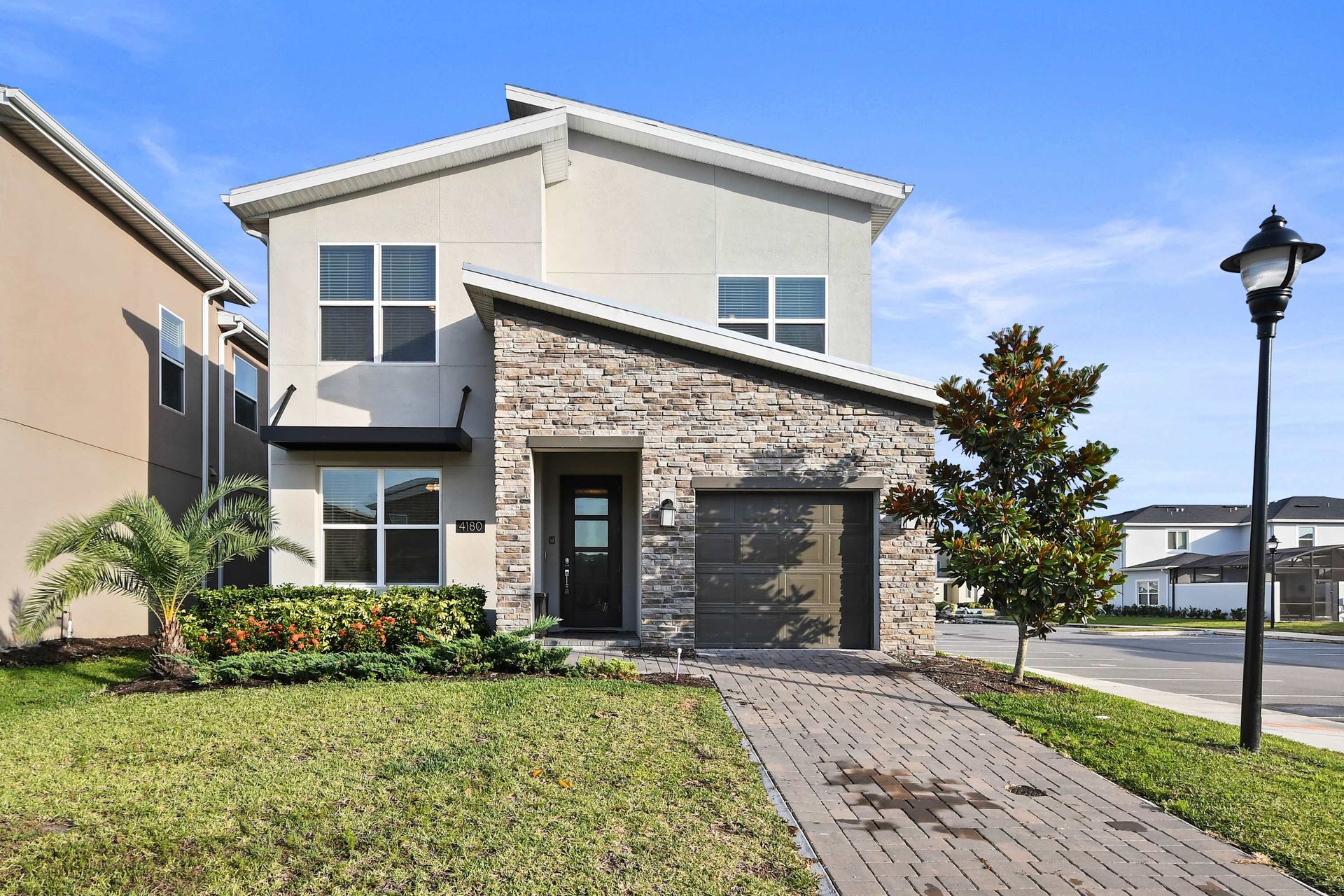 Modern two-story home with stylish stone accents in a peaceful neighborhood setting.