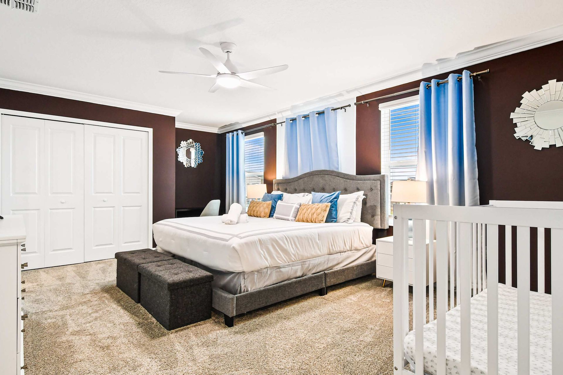 The master bedroom features a luxuriously large king bed with a crib.