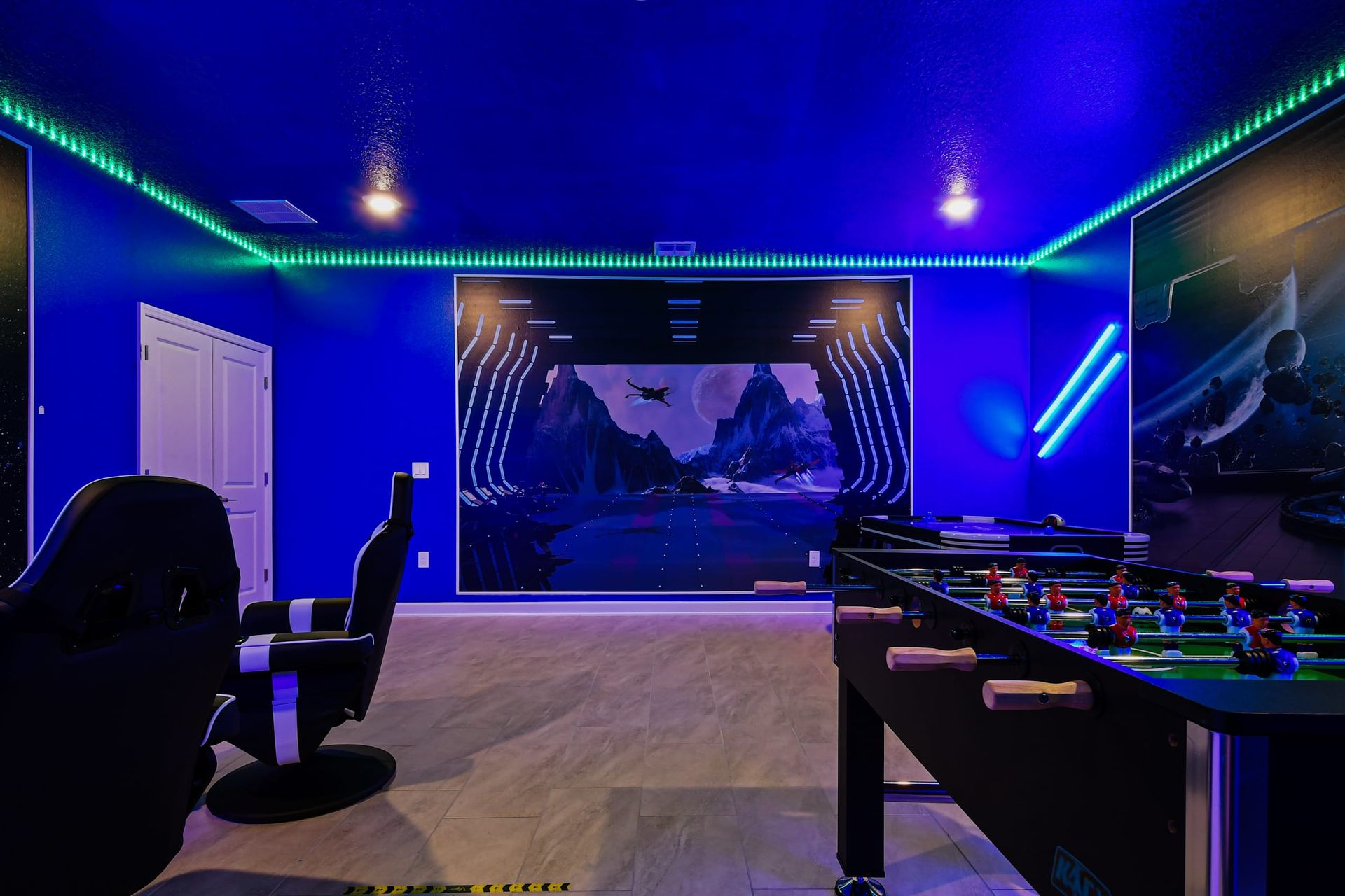 Ultimate sci-fi game room with foosball, LED lighting, theater chairs, and murals.