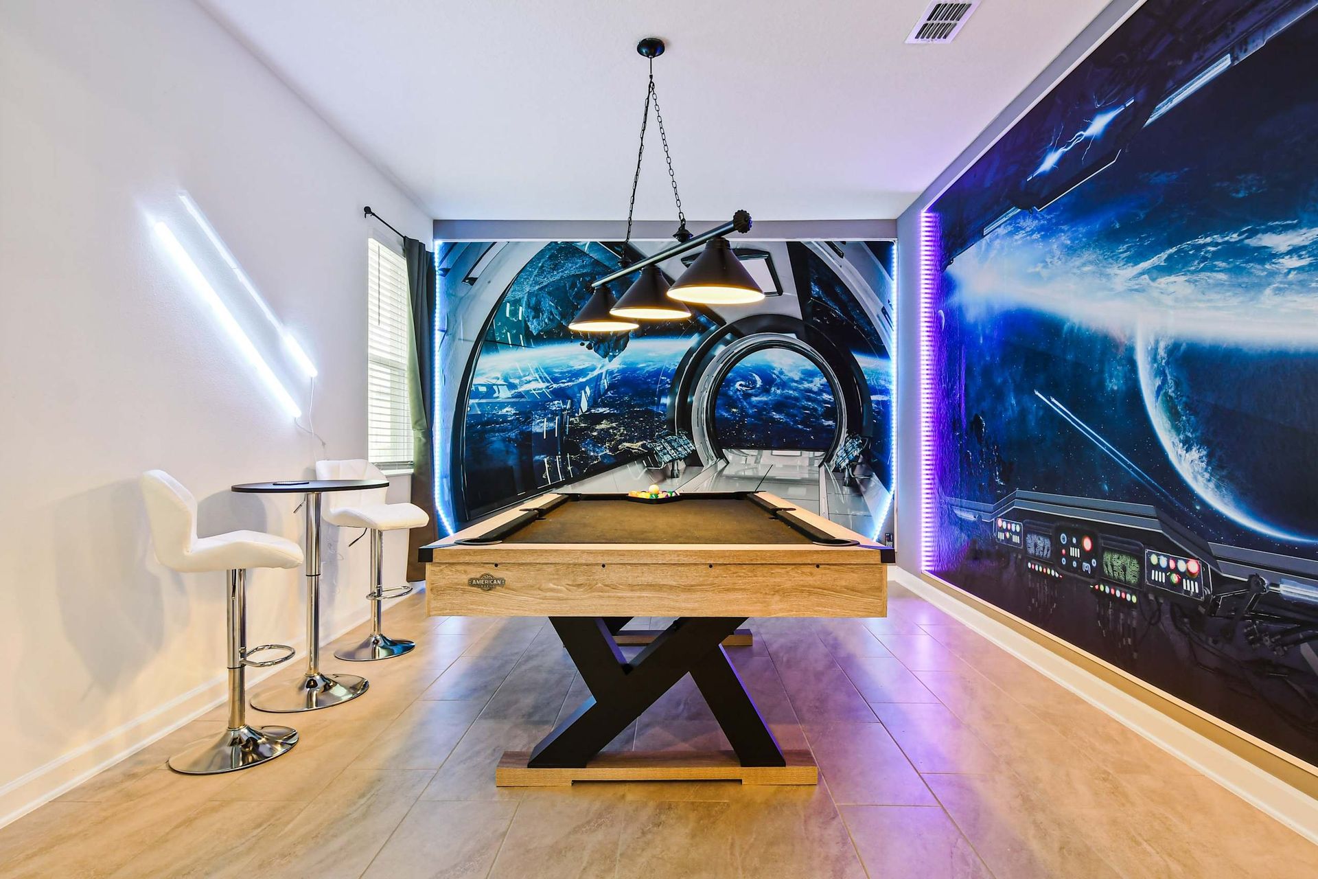 Futuristic game room with space station mural, pool table, and neon-lit flair.