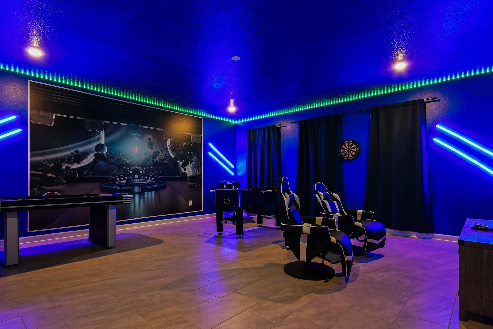 Immersive galactic game room with theater seating, arcade games, and neon lights.